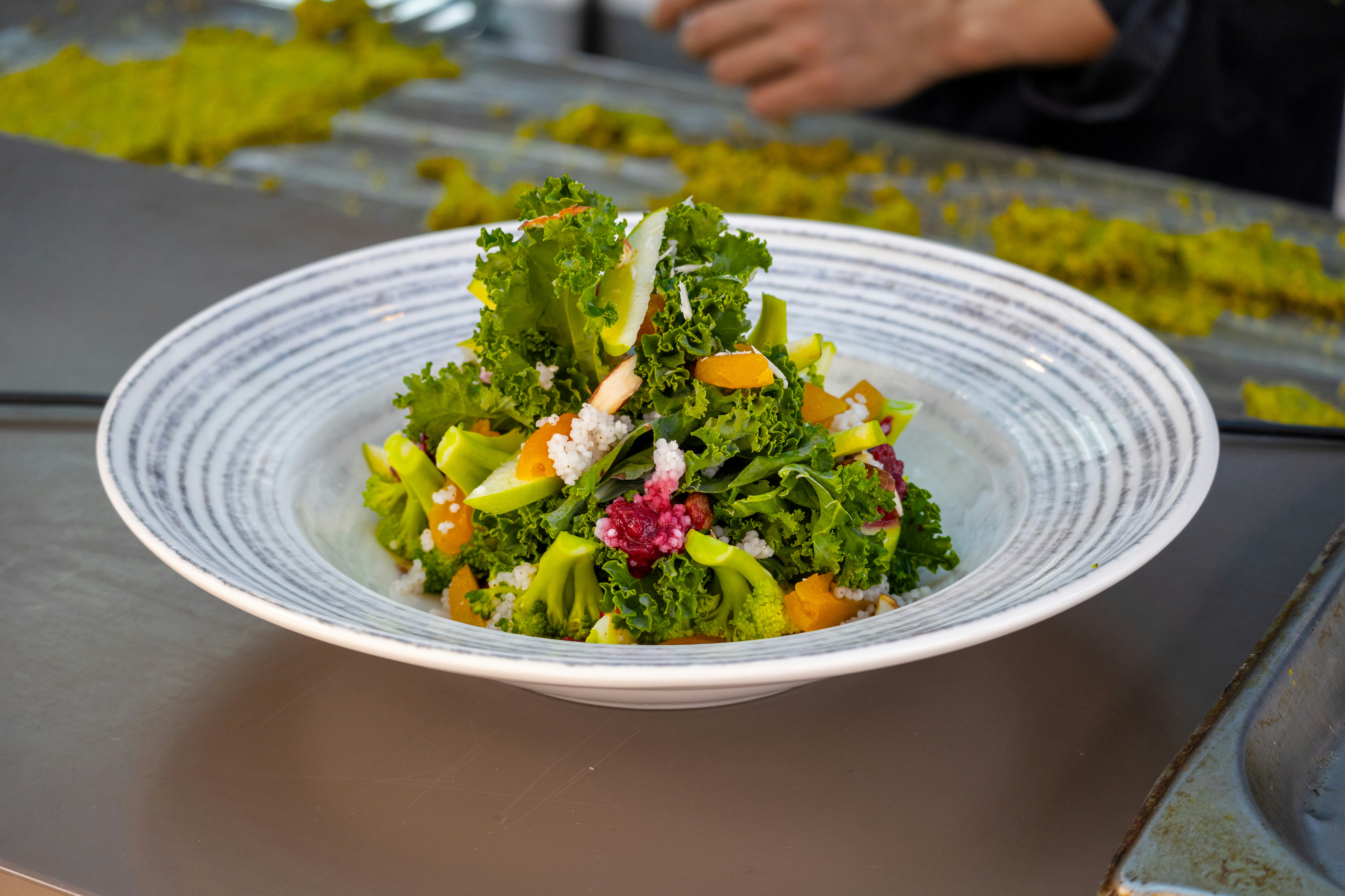 A white plate topped with a salad on top of a table
