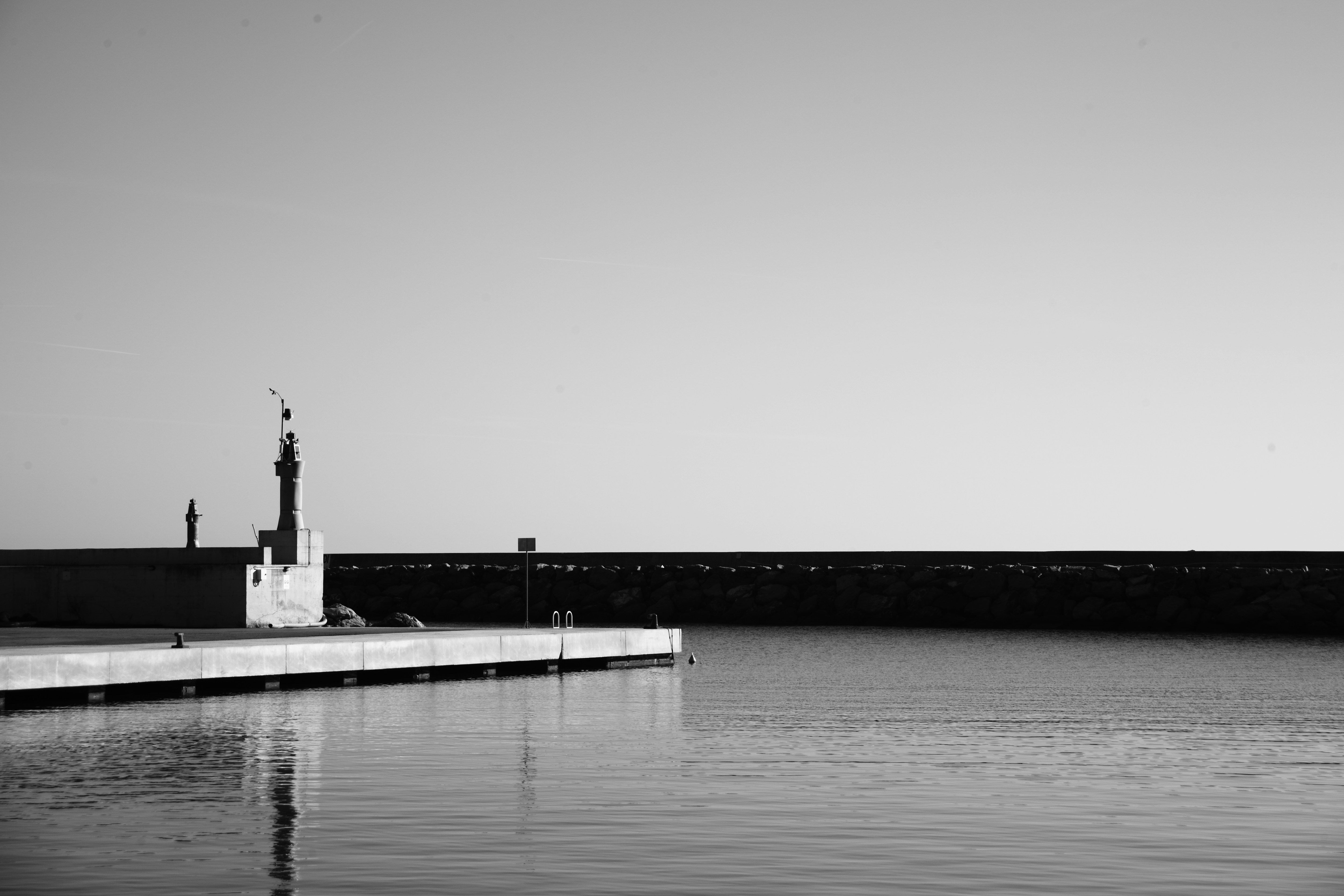 A black and white photo of a lighthouse in the water