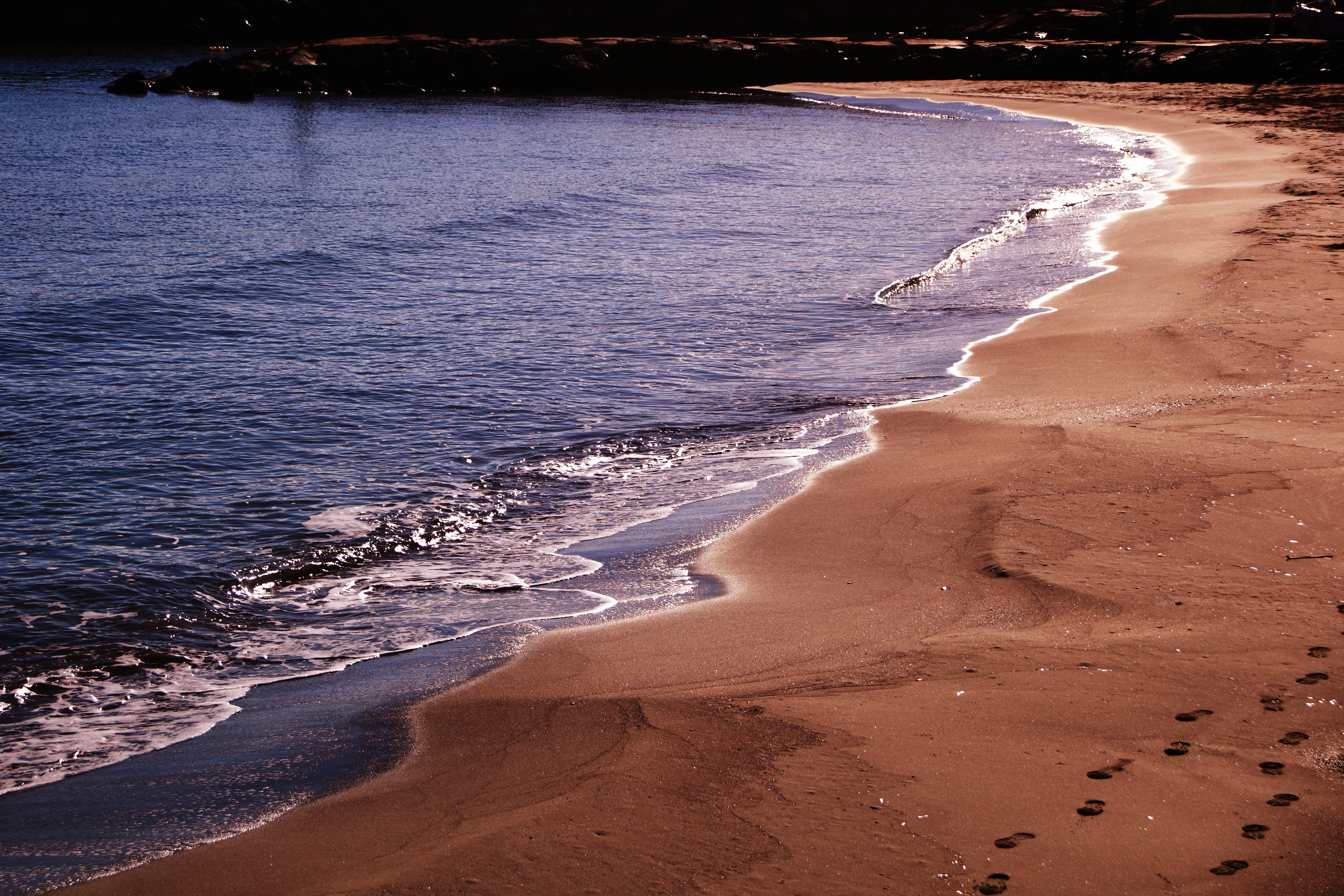 A view of a beach with footprints in the sand