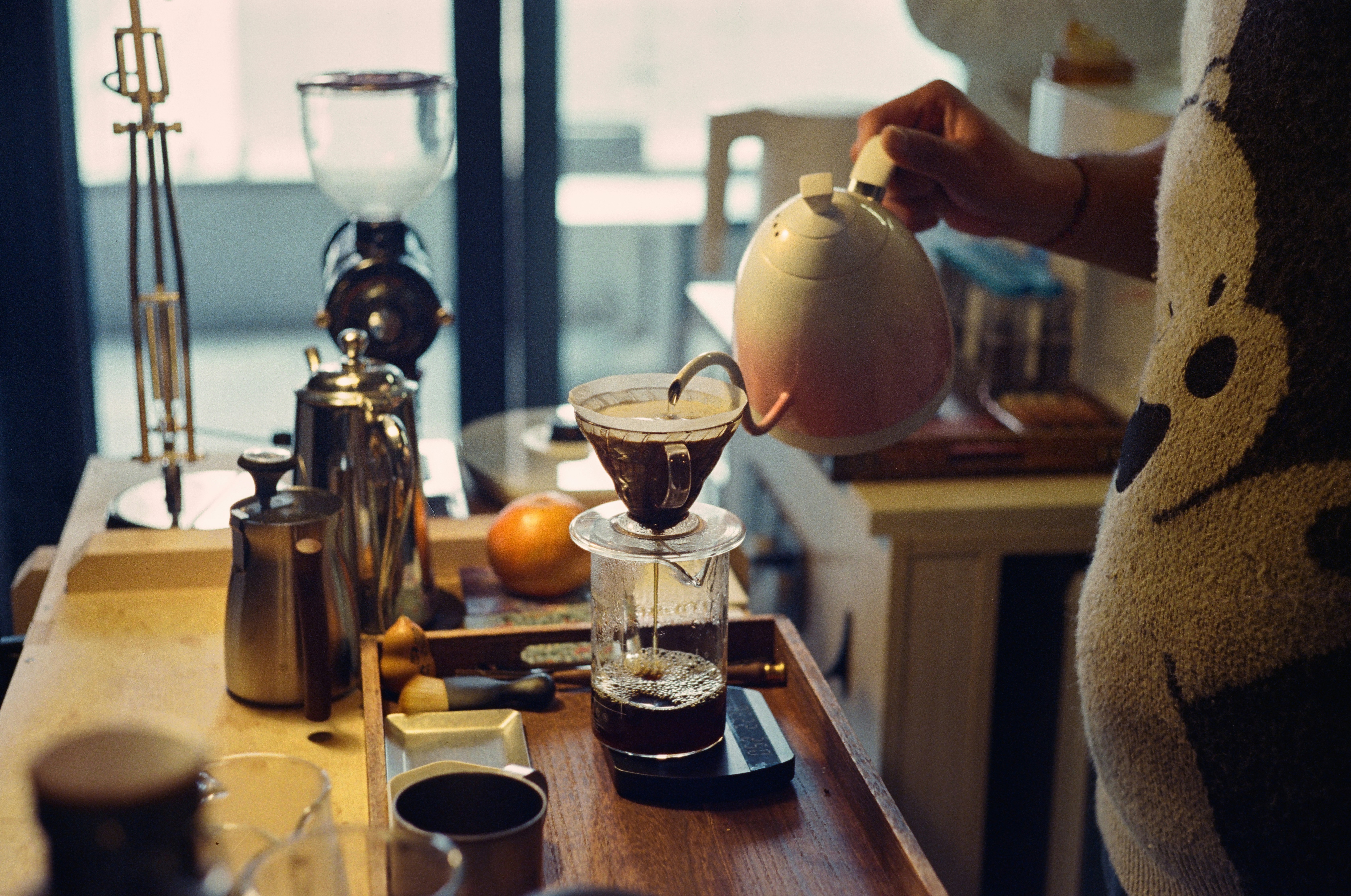 A woman pours a cup of coffee in a kitchen
