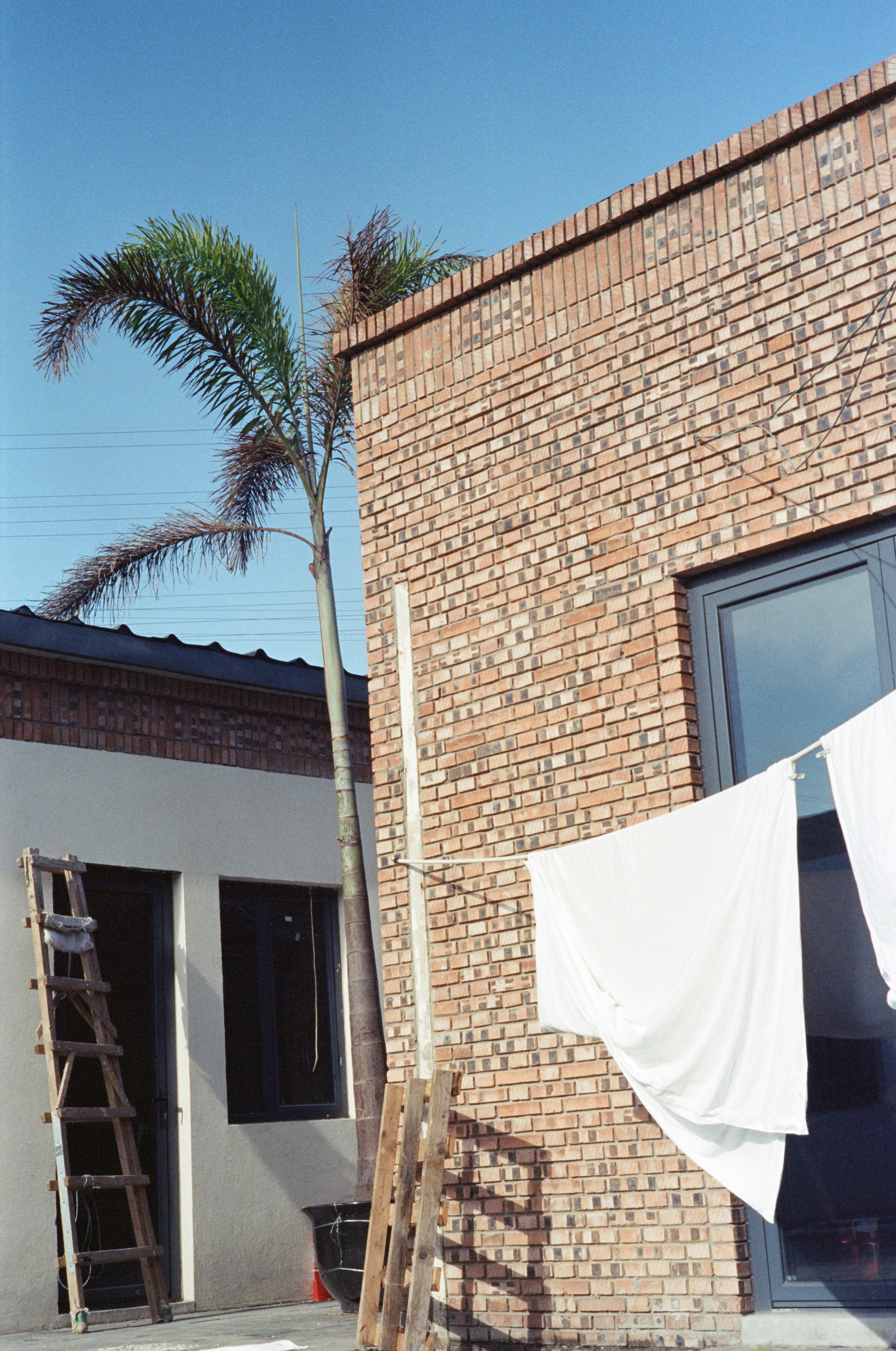 A brick building with a white tarp hanging from it's side