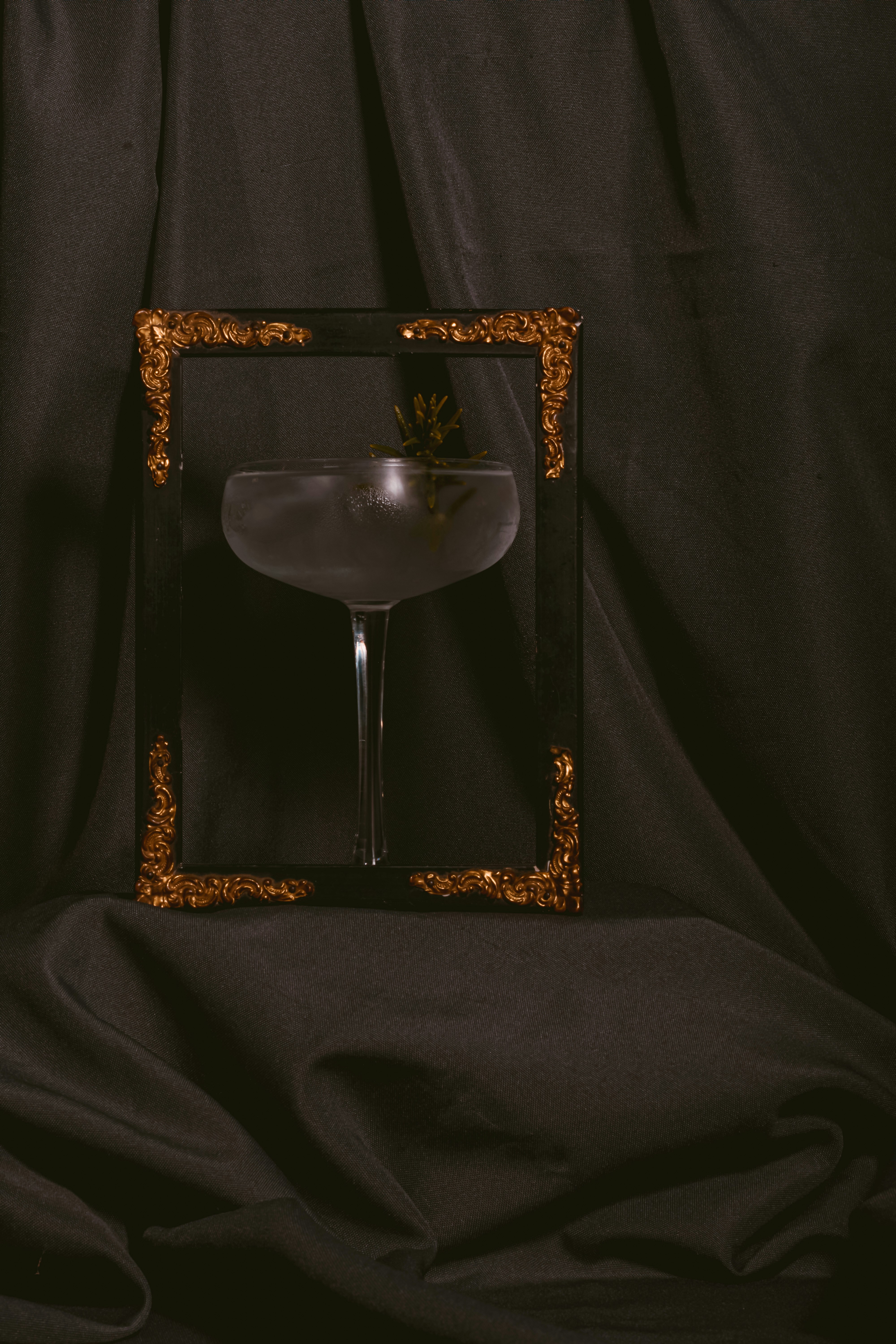 A wine glass sitting in front of a black backdrop