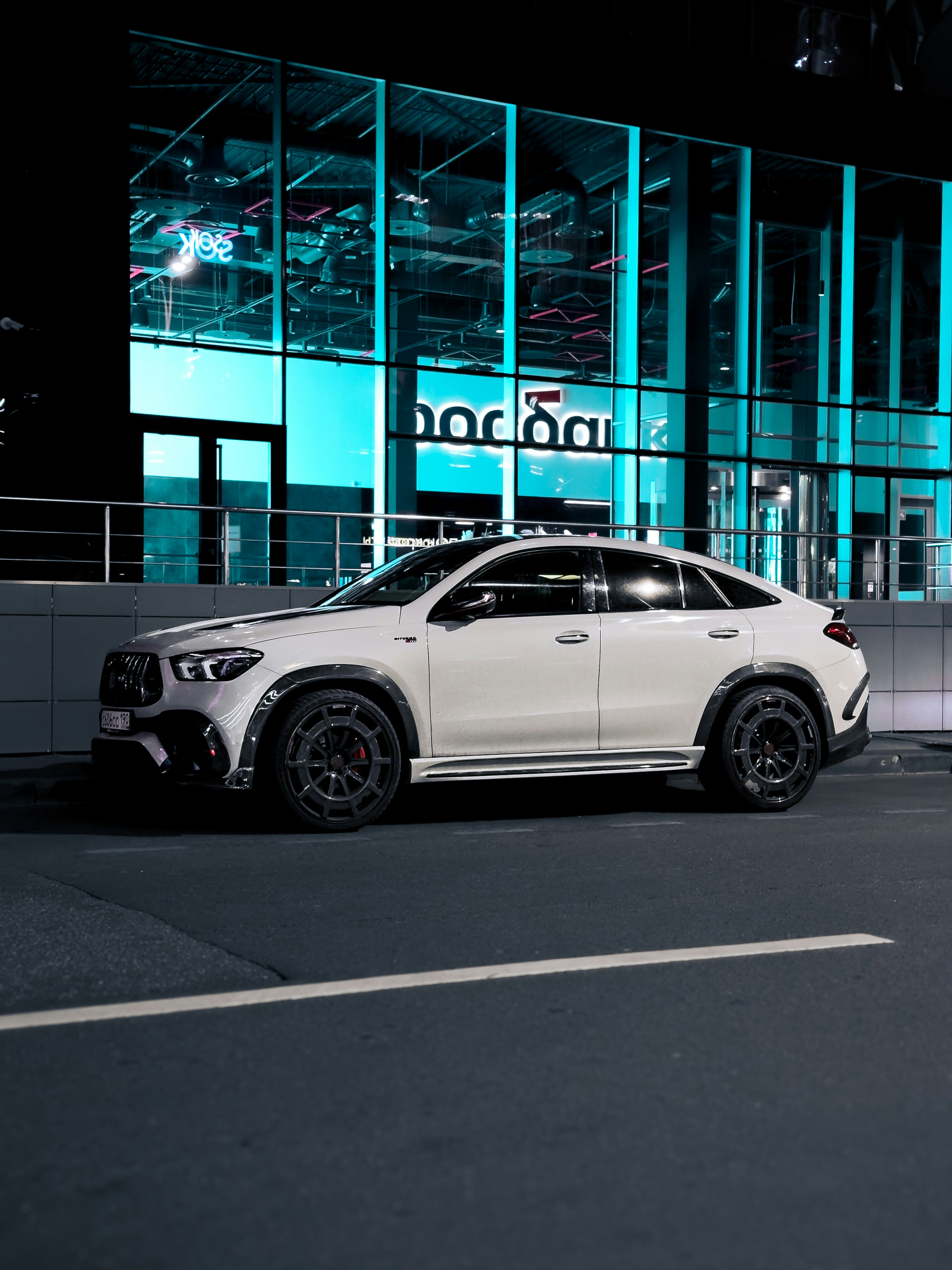 Une voiture blanche garée devant un immeuble