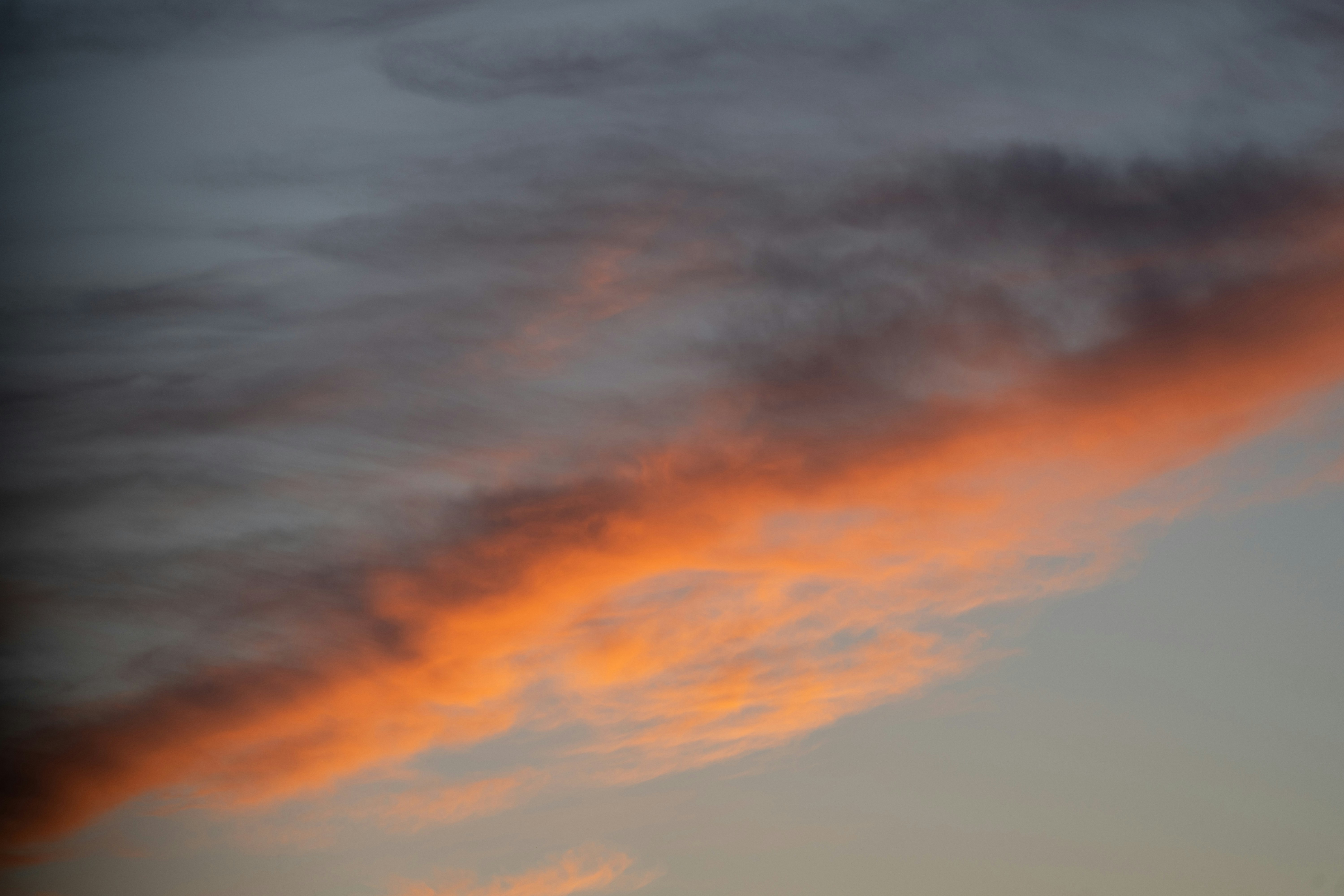 A plane flying in the sky with a sunset in the background