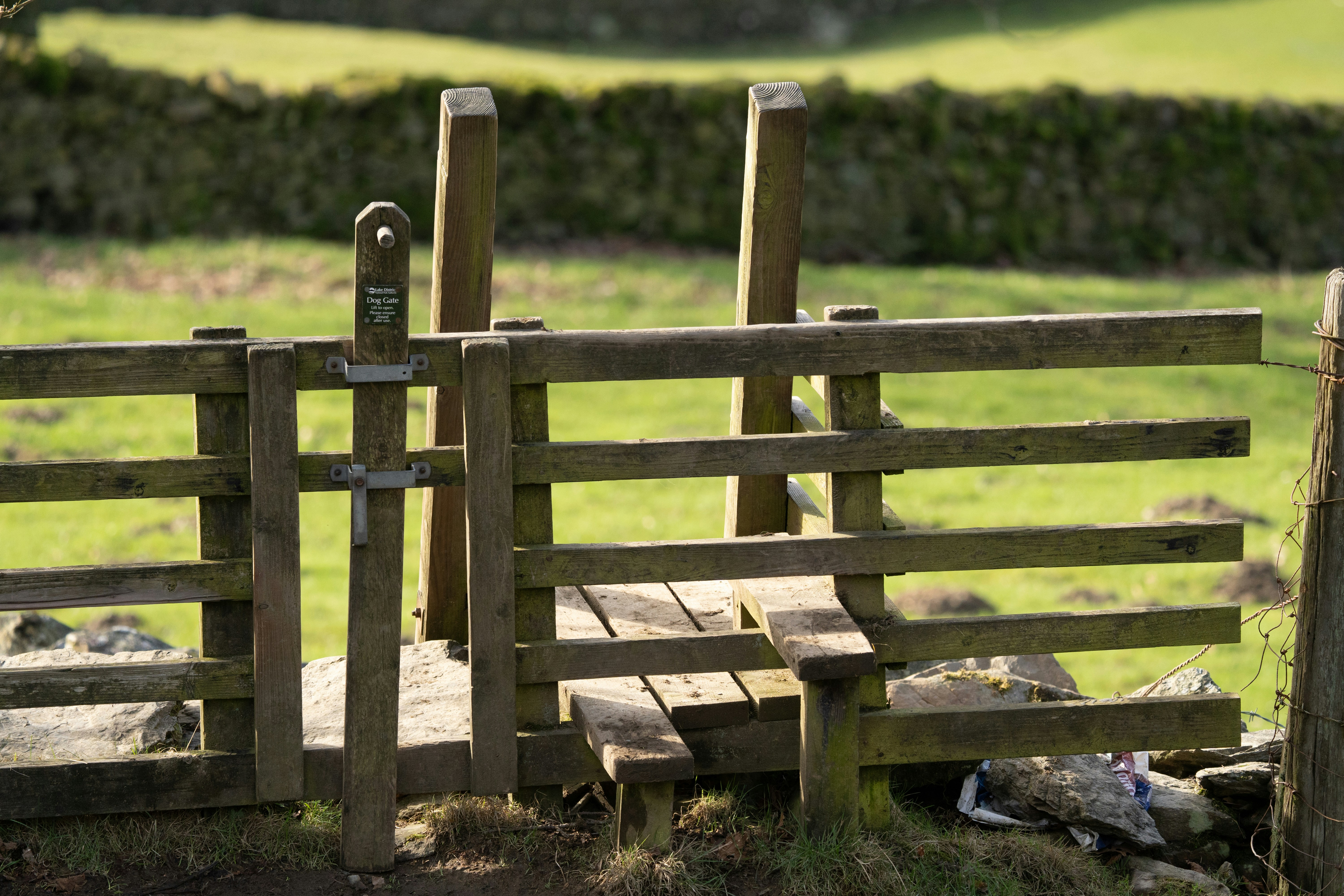 A wooden fence in a grassy field