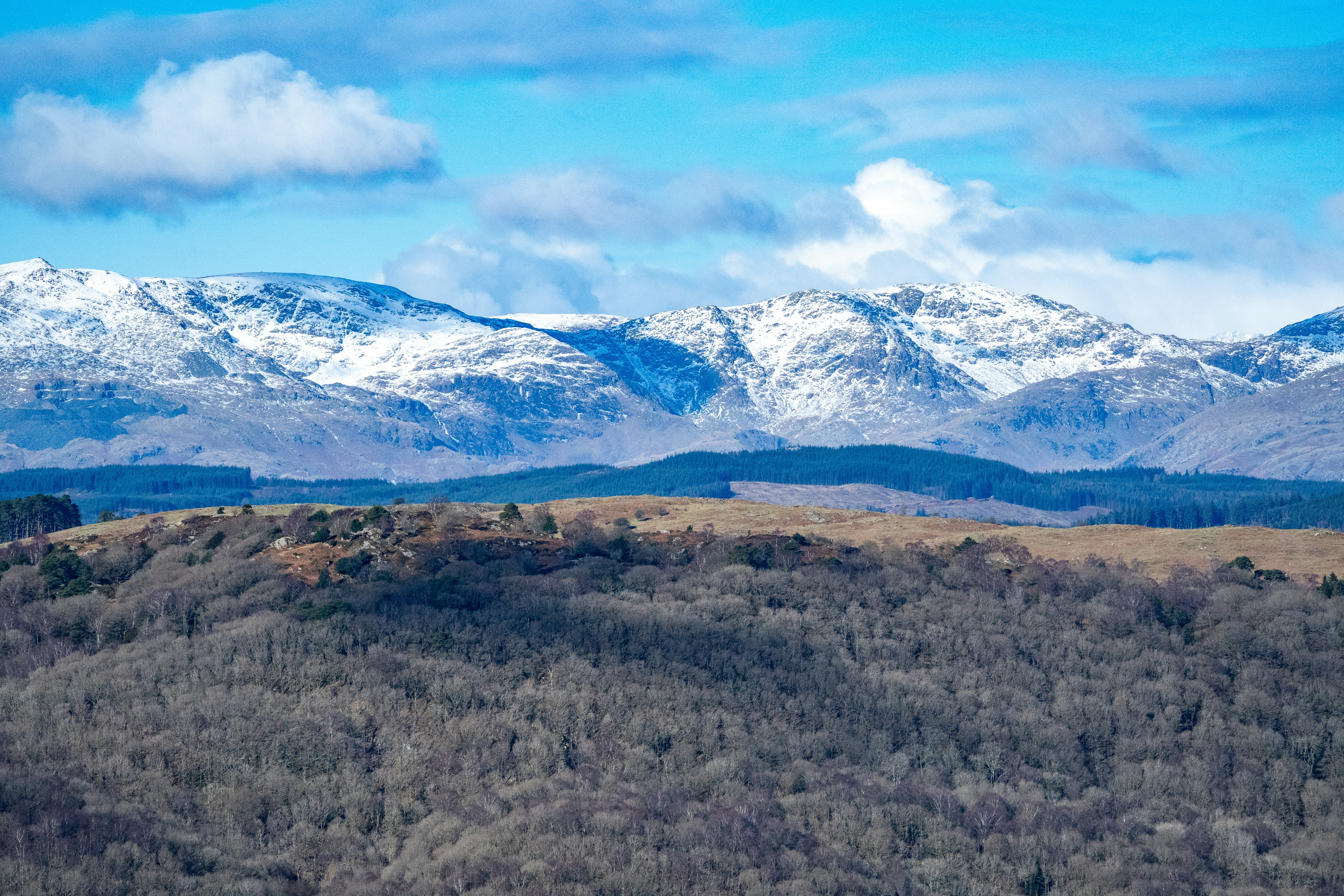 A mountain range with snow capped mountains in the distance