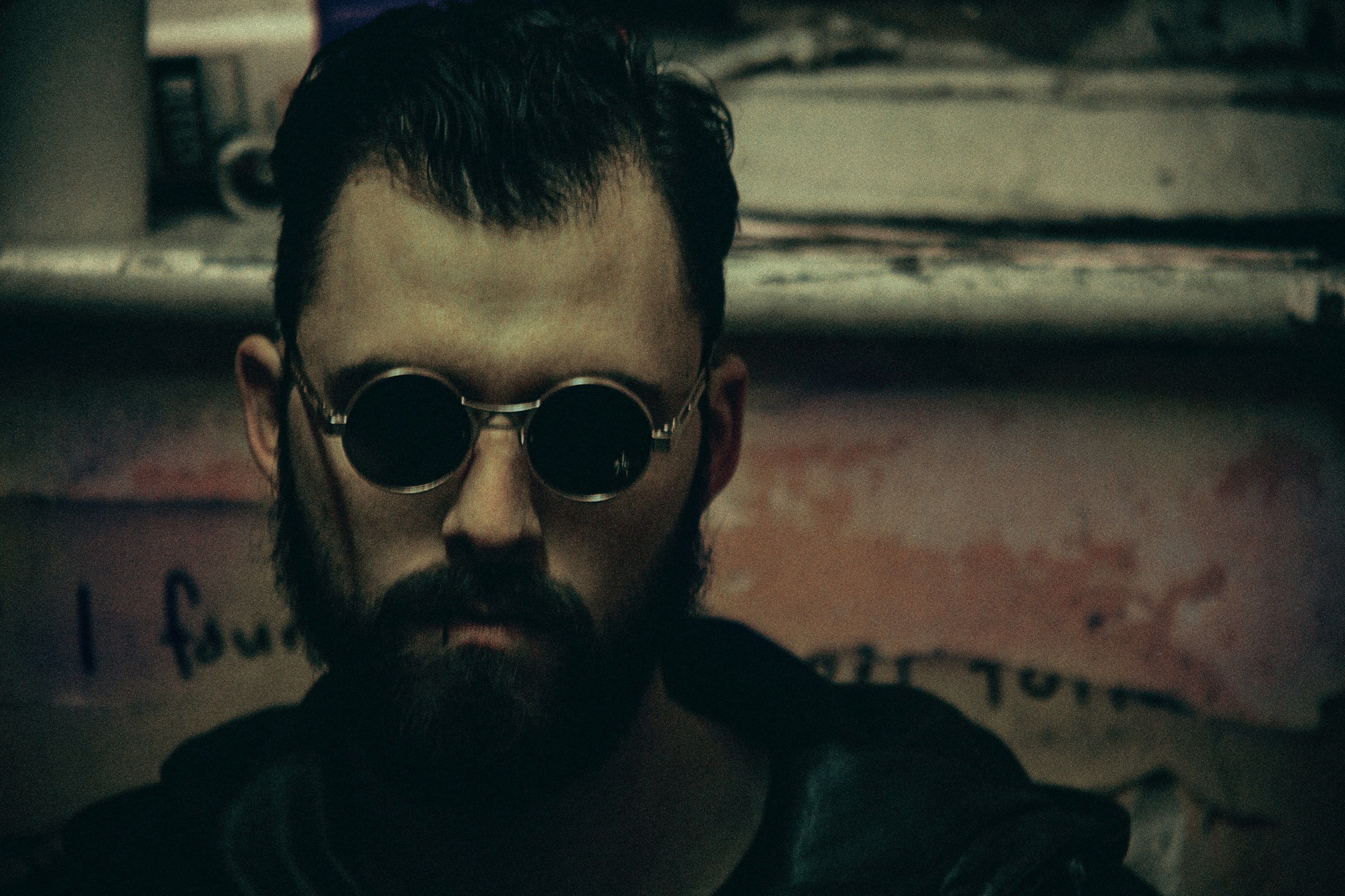 Ein Mann mit Spitzbart und Sonnenbrille schaut in die Kamera
