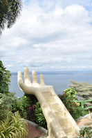 A statue of a hand reaching out to the ocean