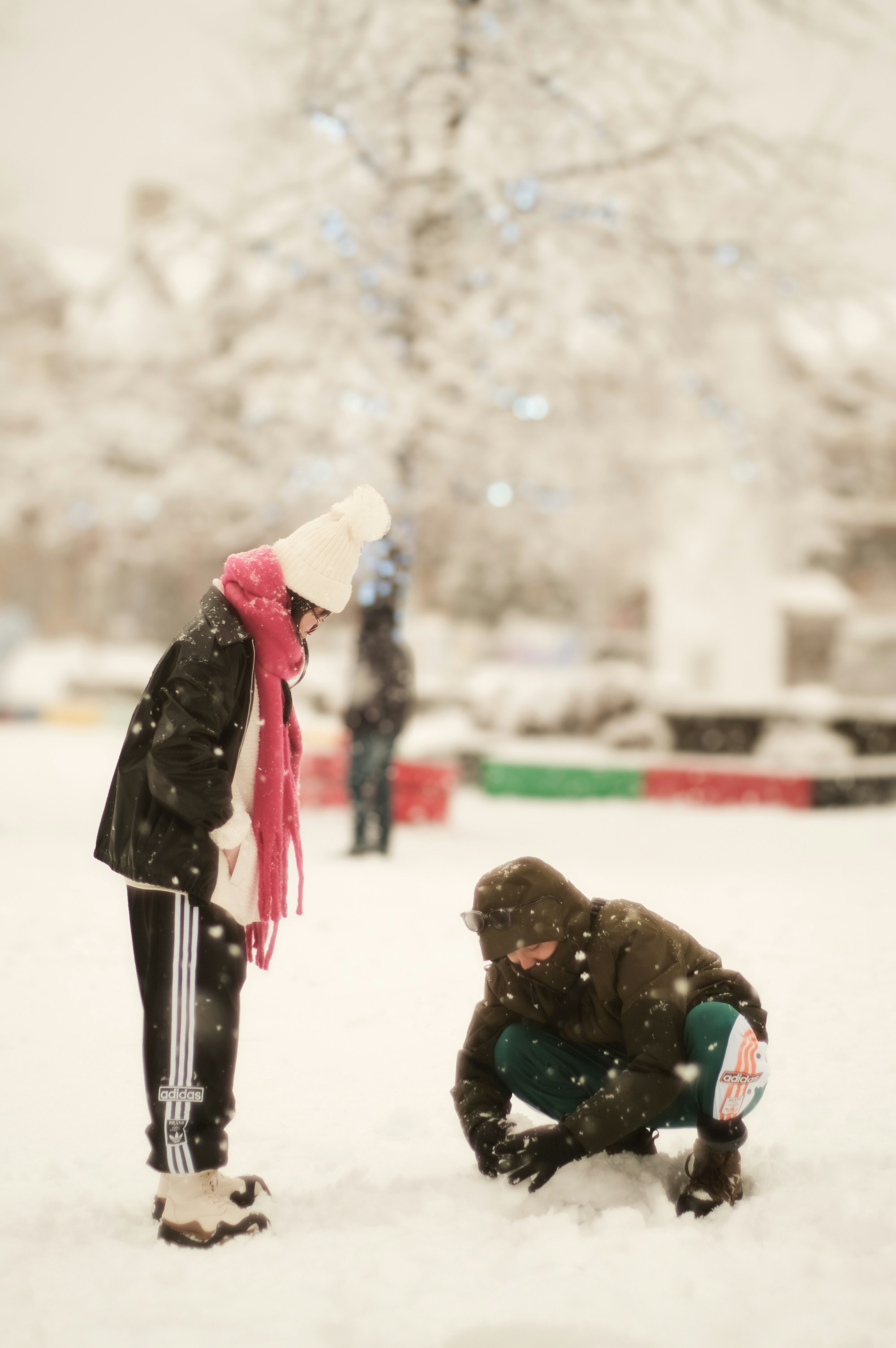 Two people are playing in the snow with a frisbee