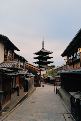 A narrow street with a pagoda in the background