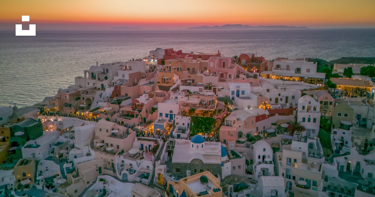 A view of a city with a sunset in the background photo – Free Santorini ...