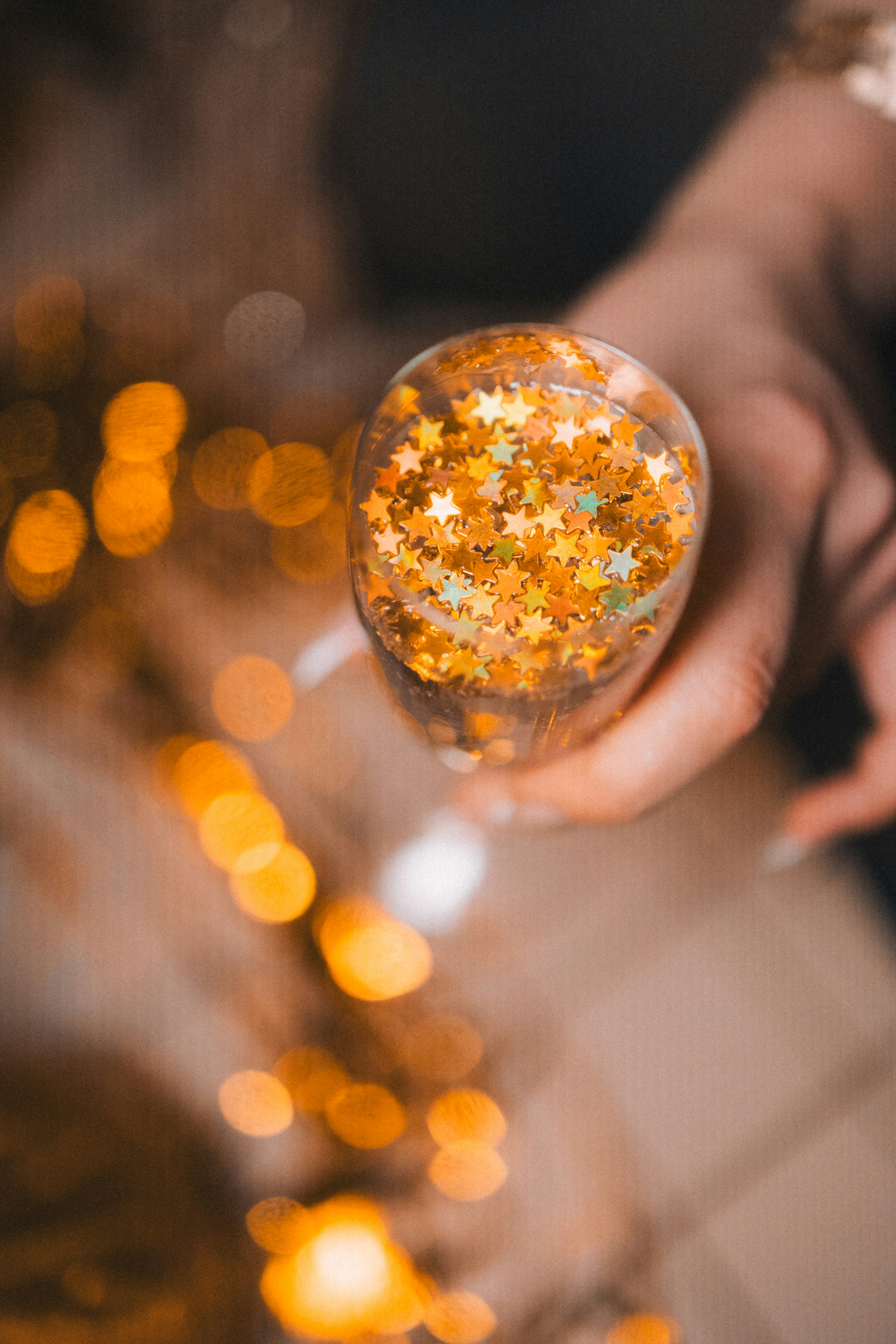 A person holding a glass filled with glitter