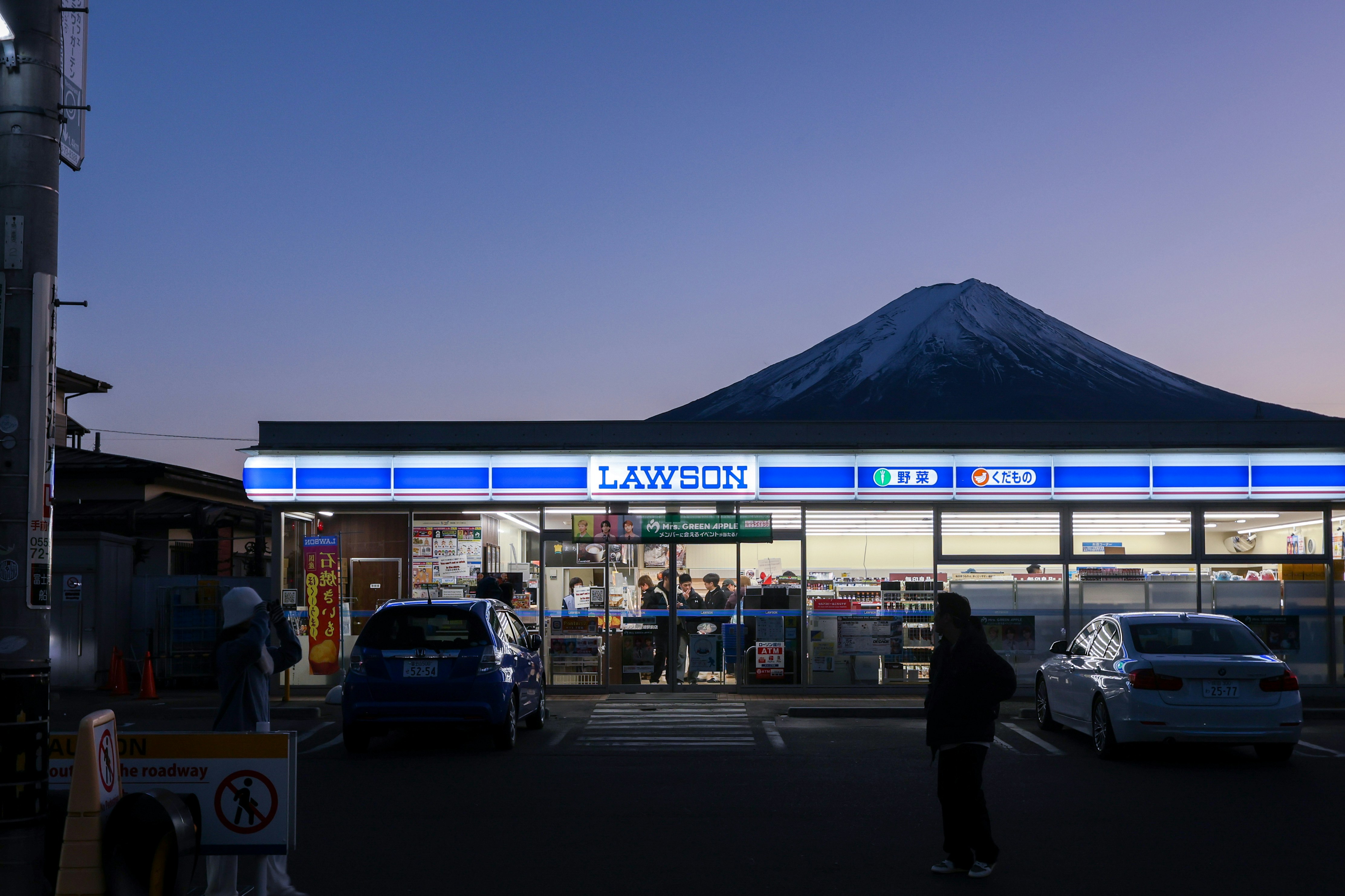 A man standing in front of a gas station