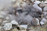 A man standing next to a pile of rocks