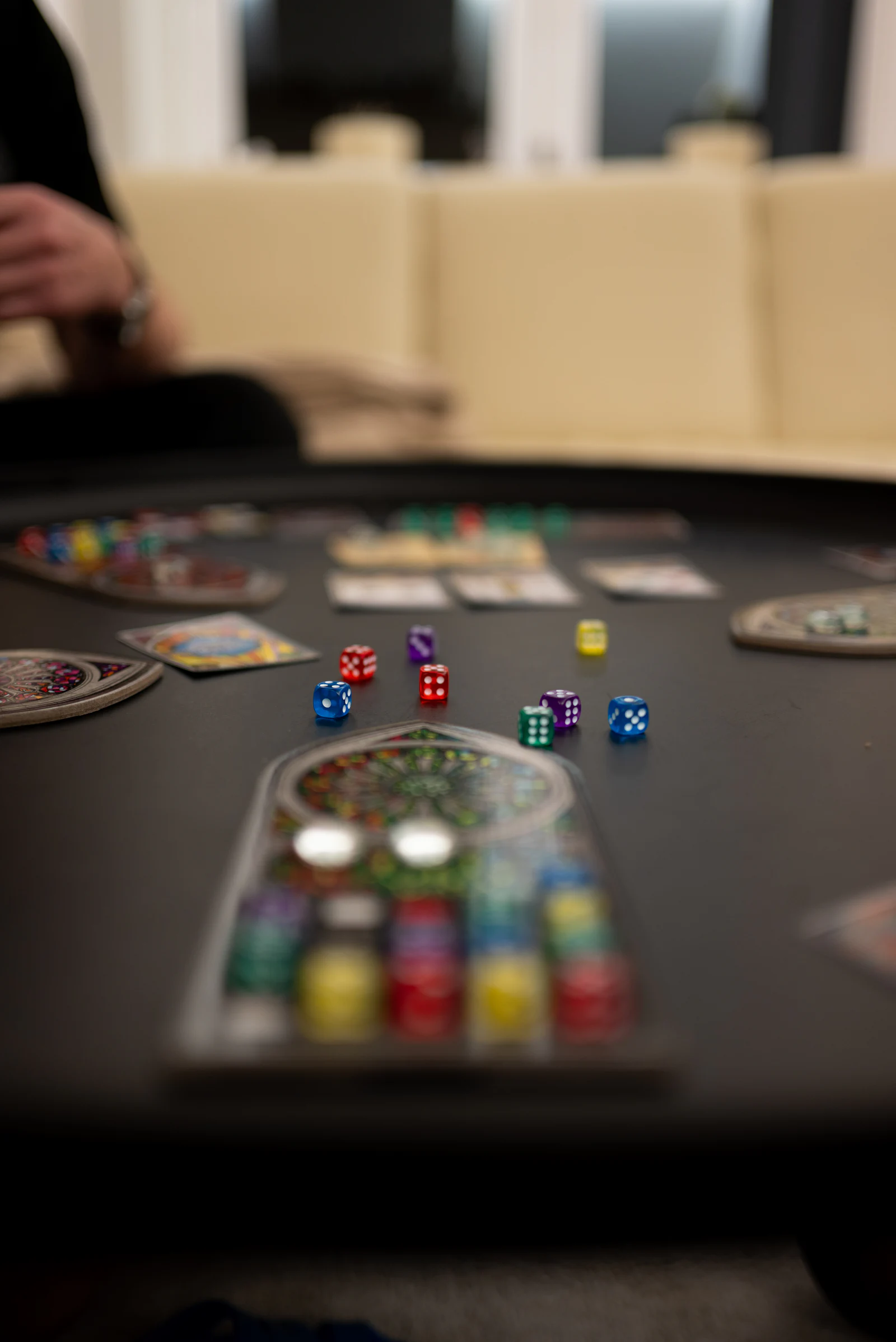 A dark table covered in scattered polyhedral dice.