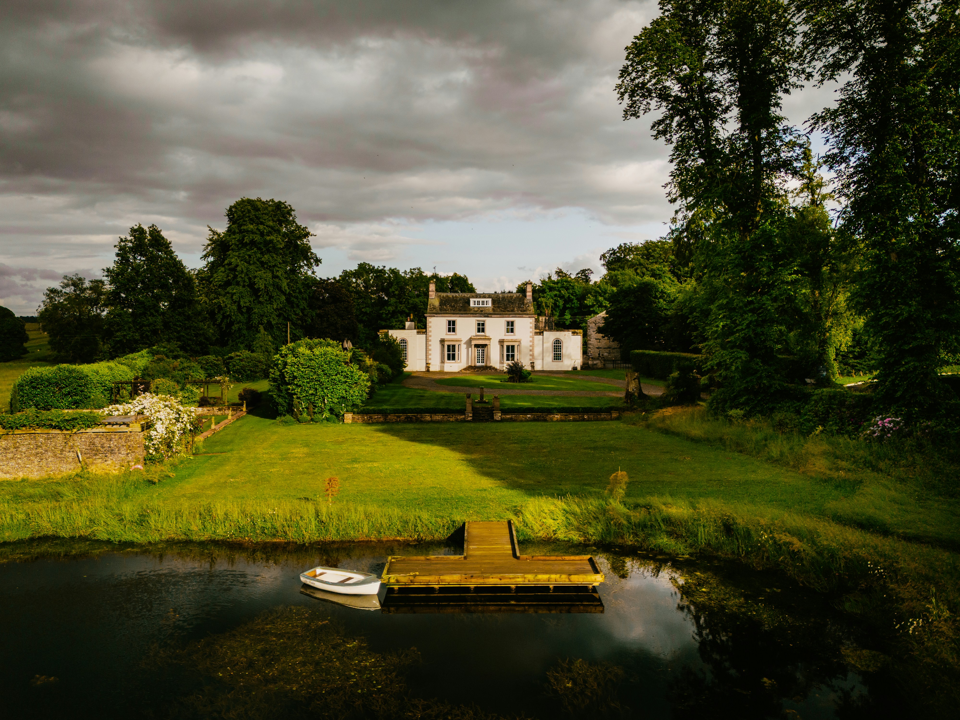 A large white house sitting on top of a lush green field