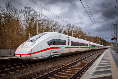 A white and red train traveling down train tracks