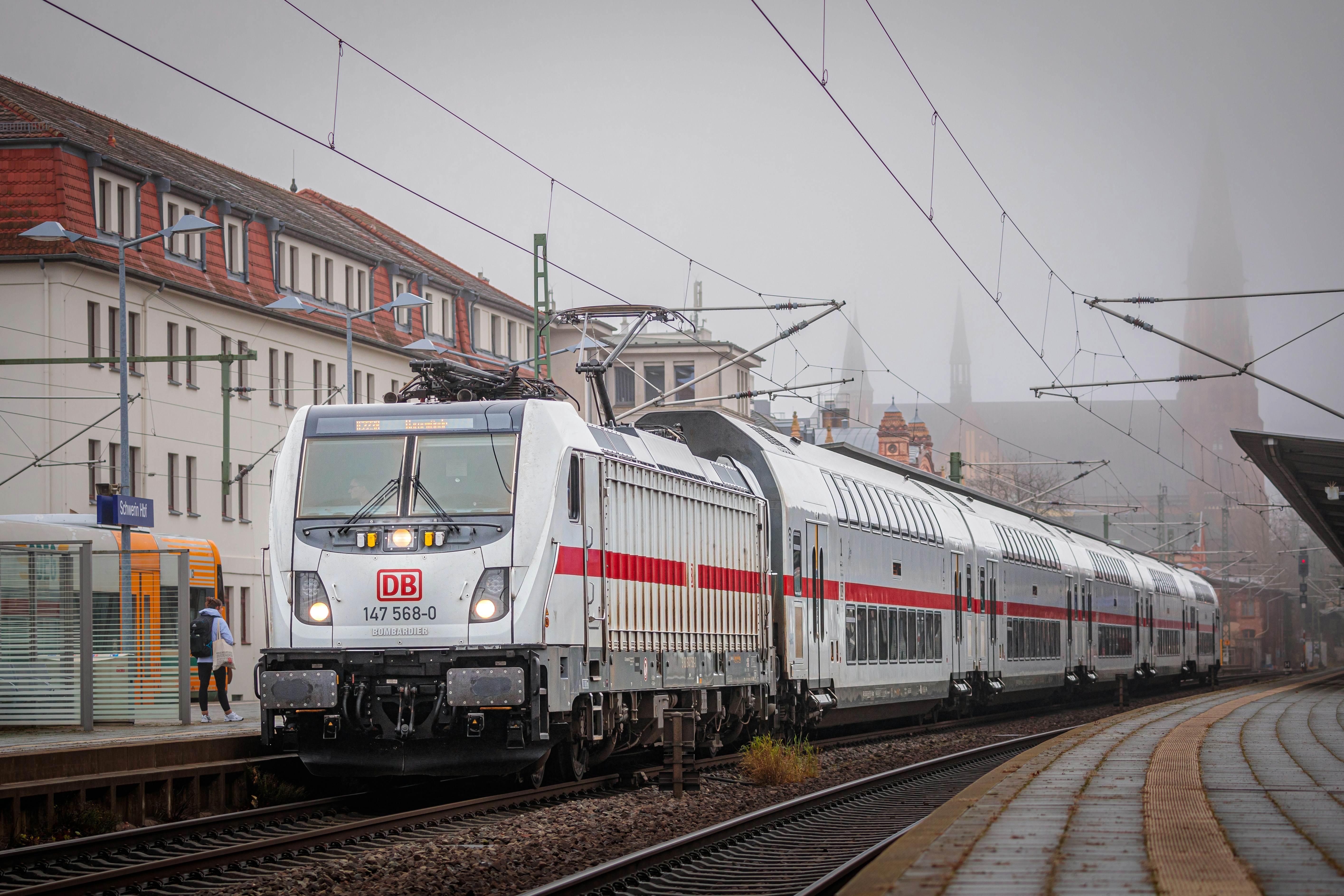 A train traveling down train tracks next to a building