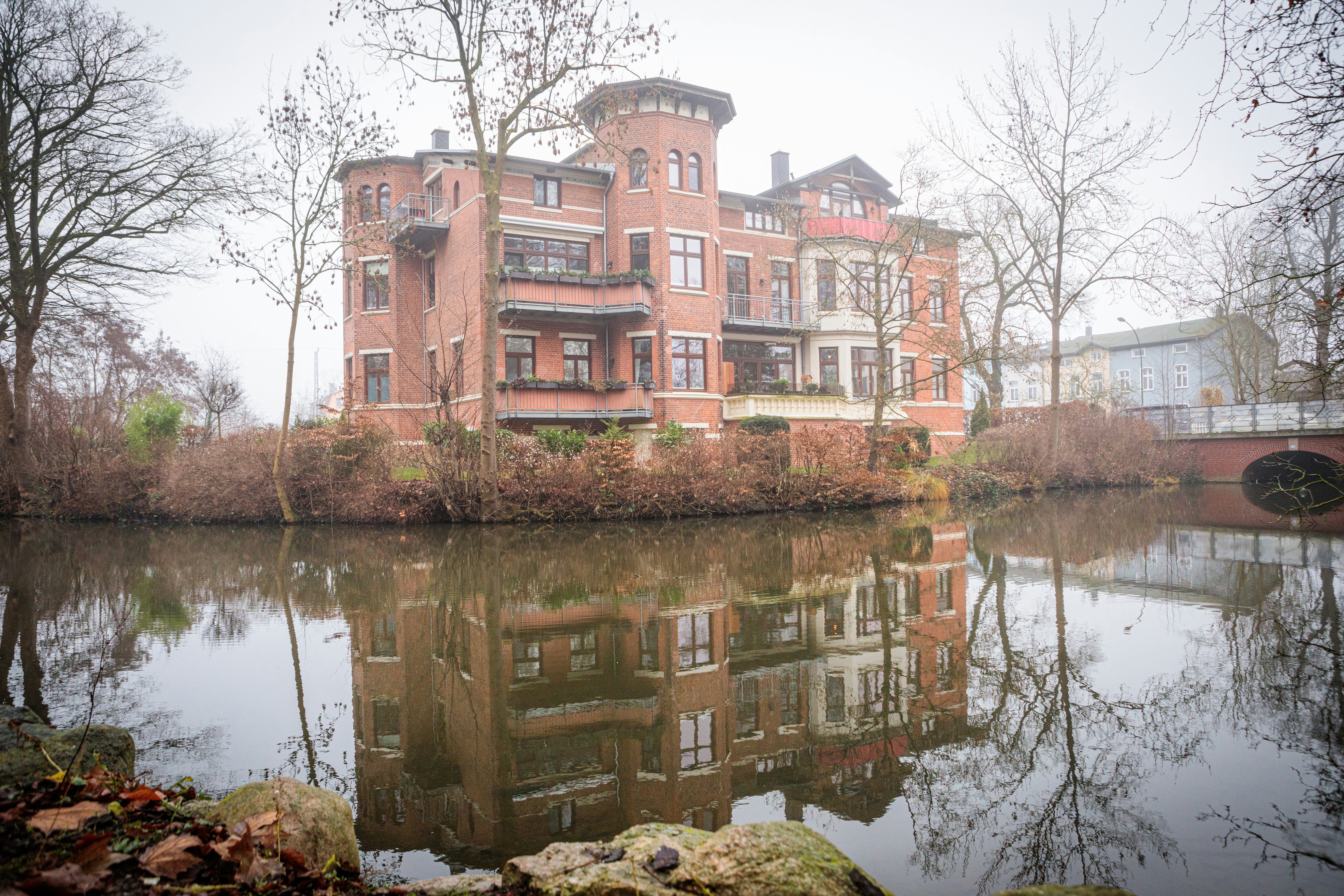 A large brick building next to a body of water