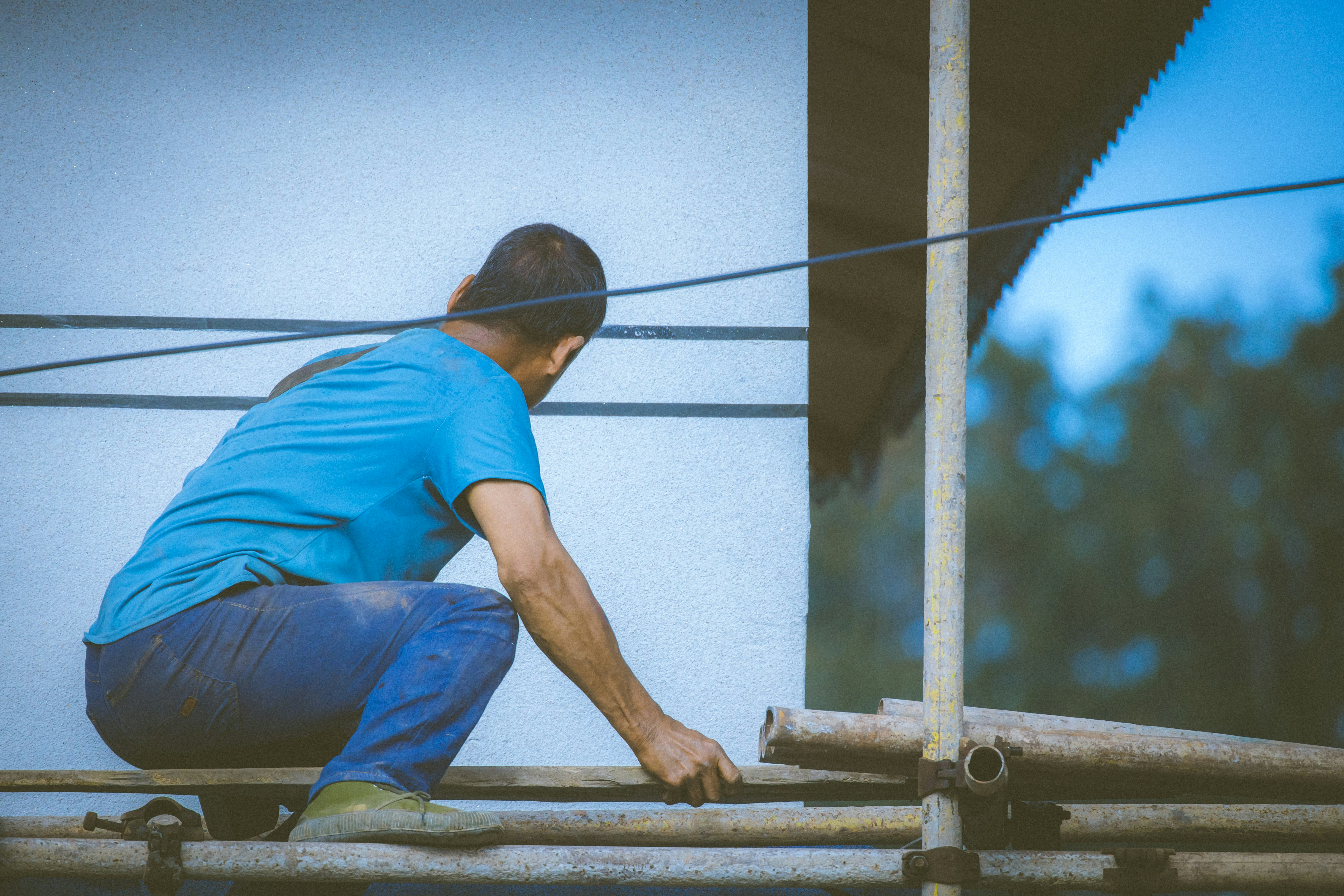A man in blue shirt working on a pipe