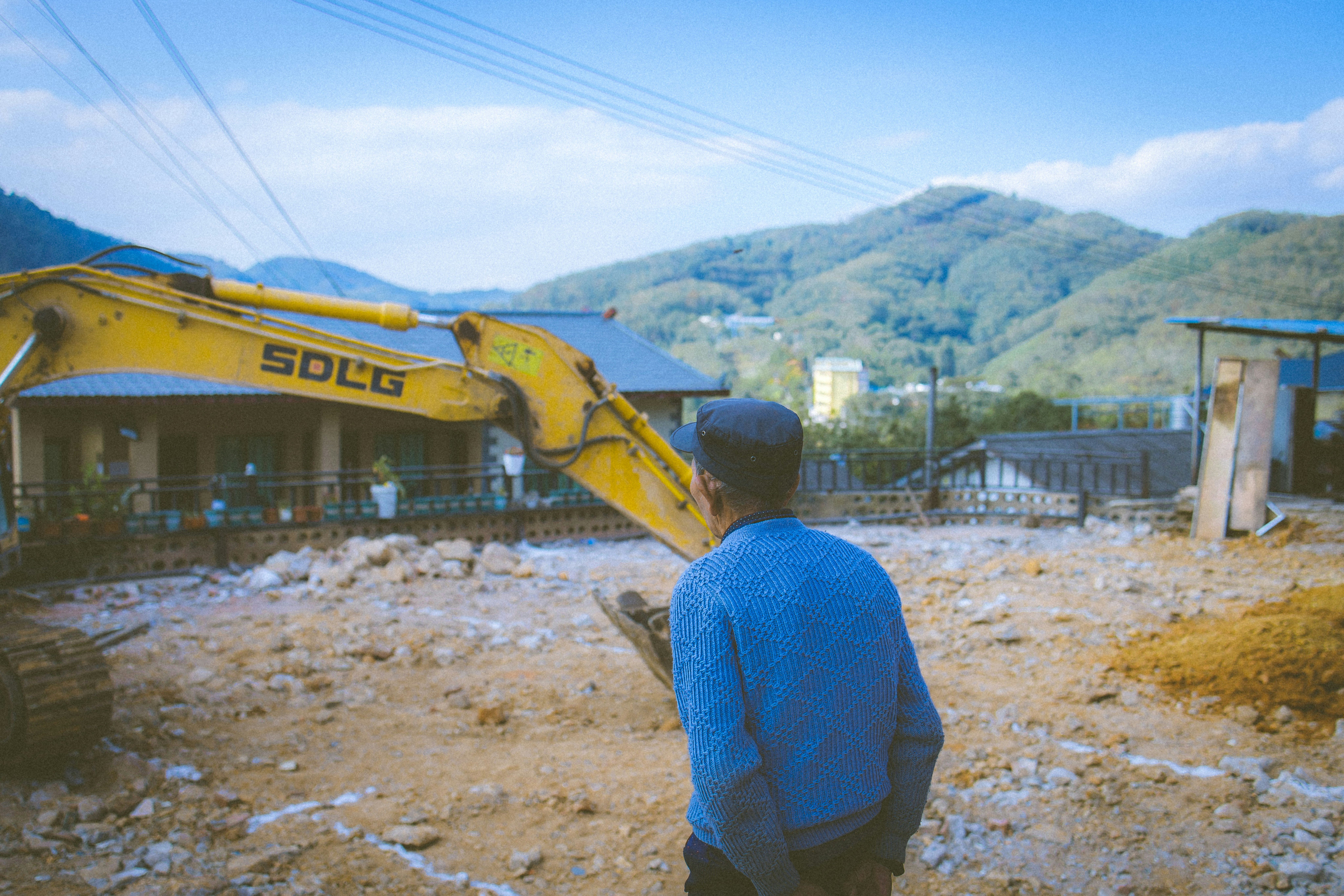 A man standing in front of a yellow bulldozer