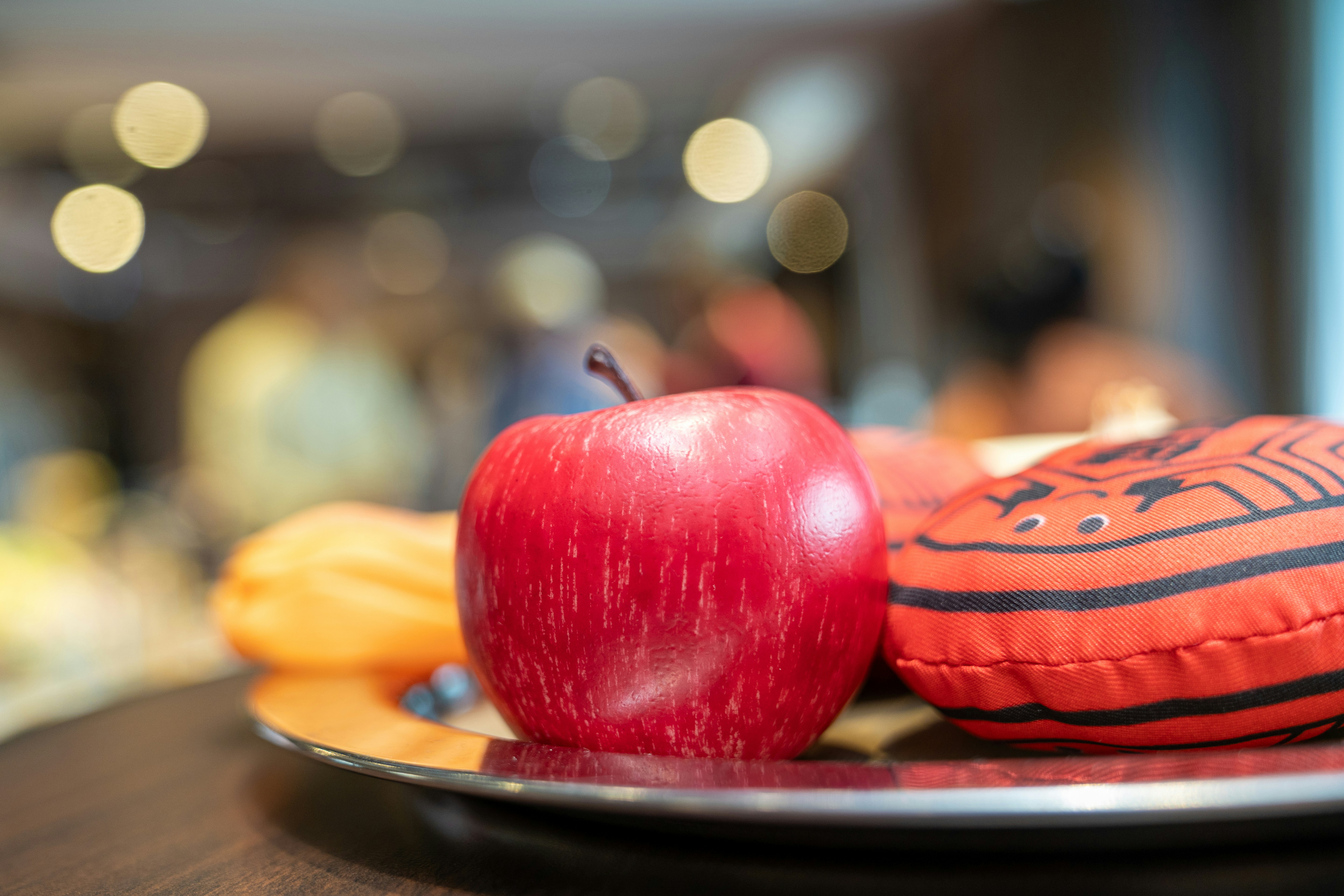 A plate with an apple and a pillow on it
