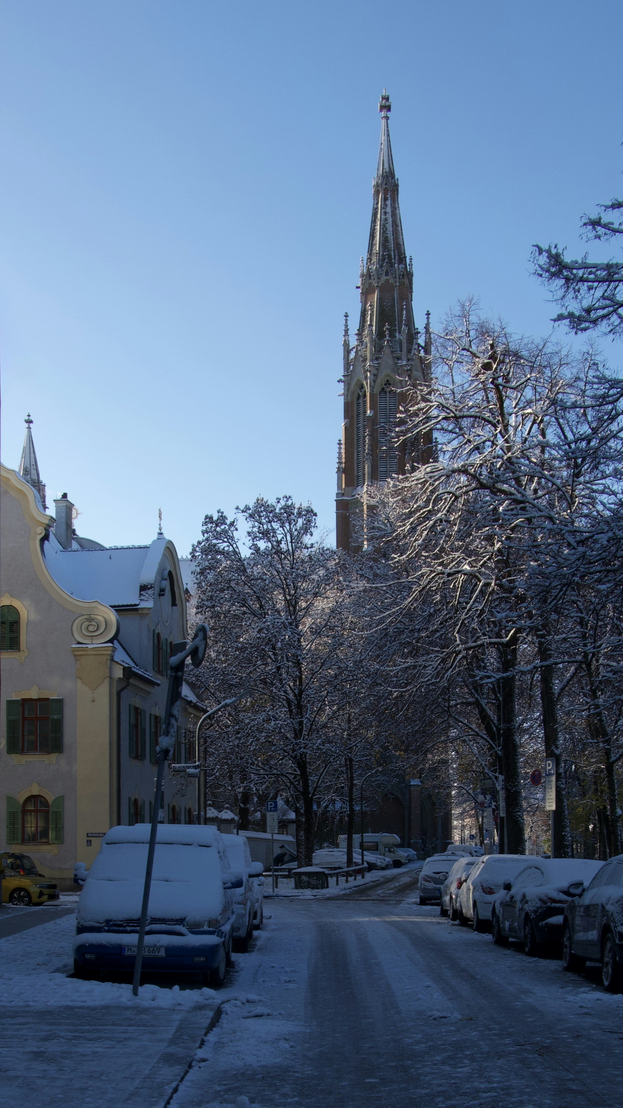A snowy street with a church in the background