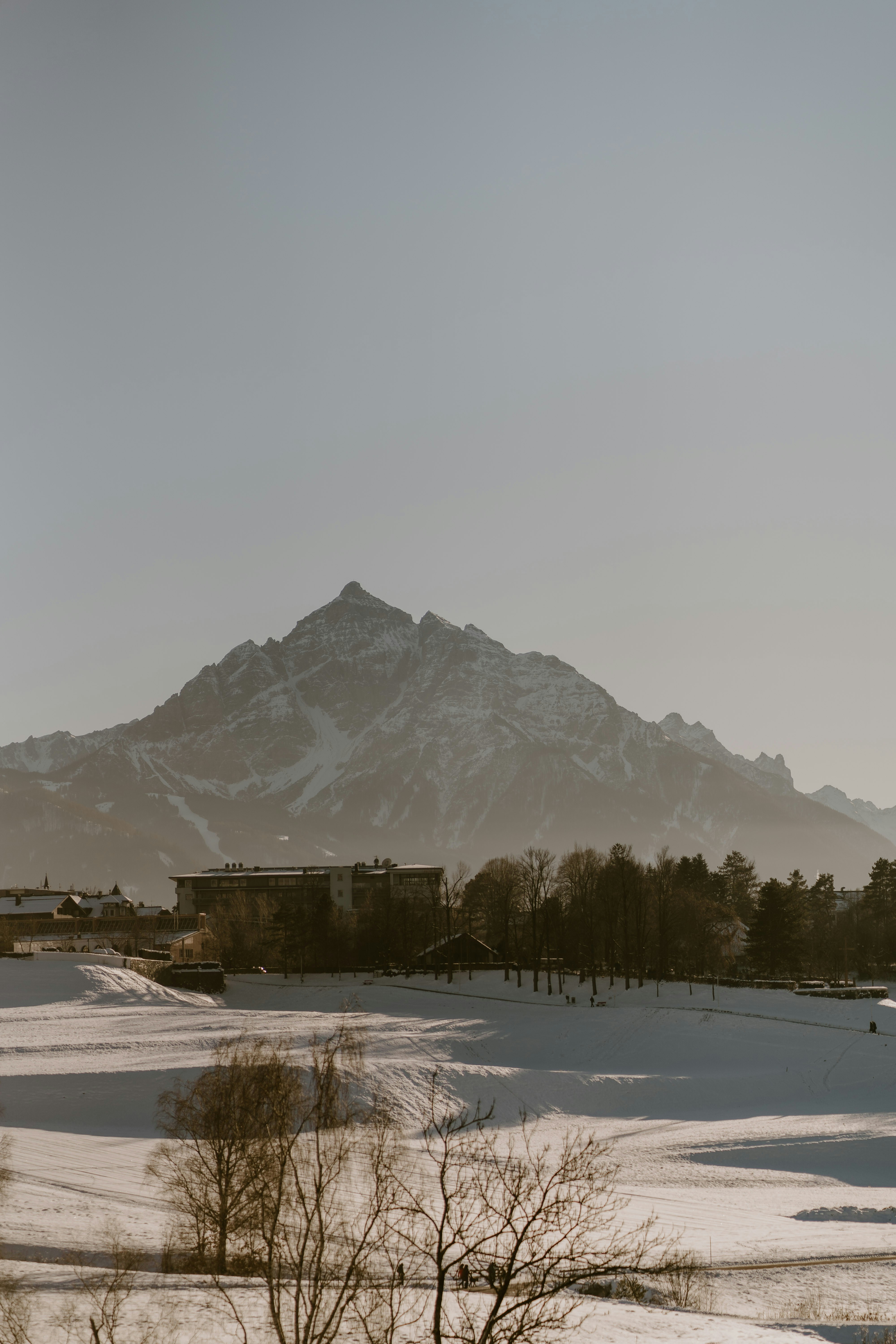 A snow covered field with a mountain in the background