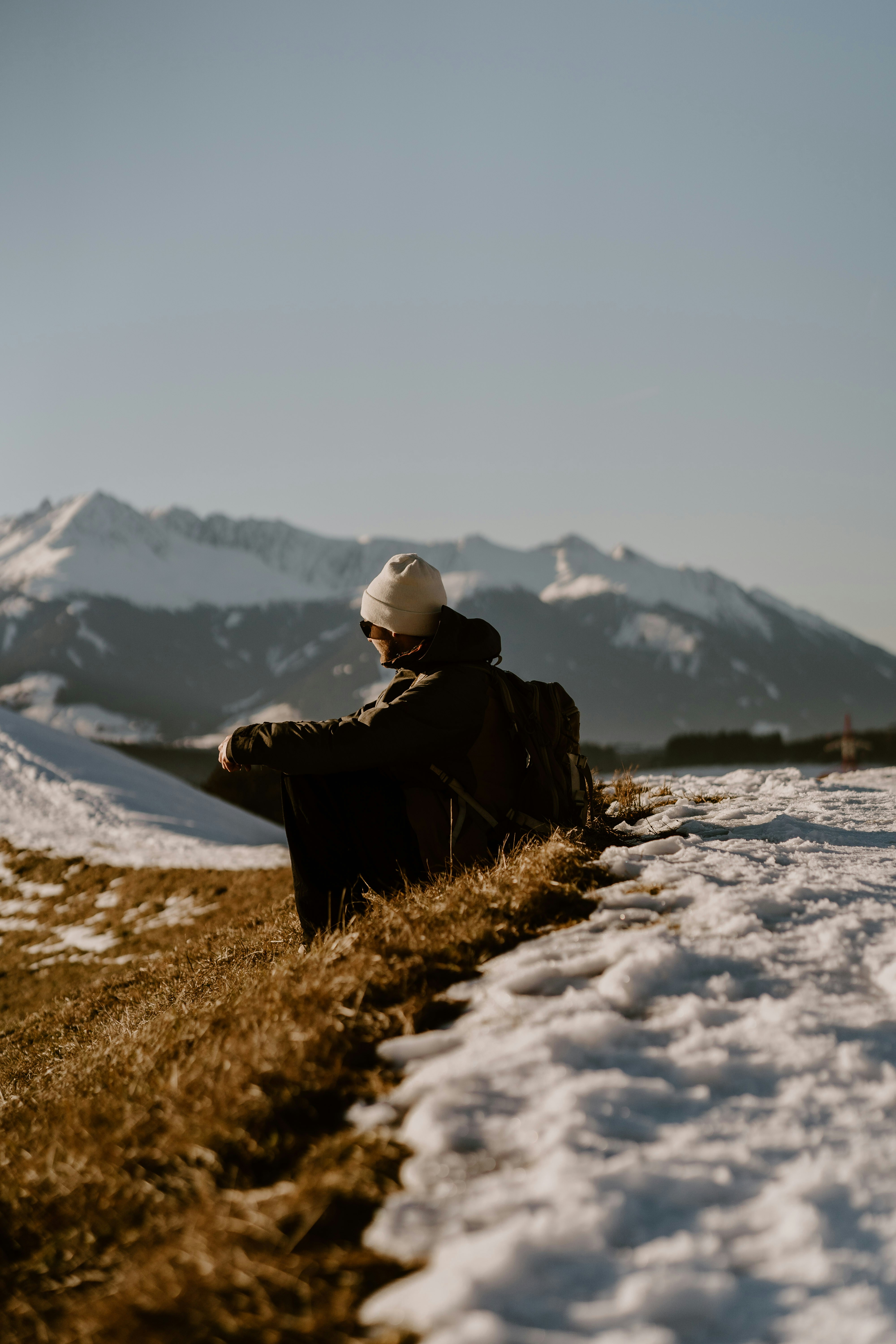 A person sitting on the side of a snow covered hill