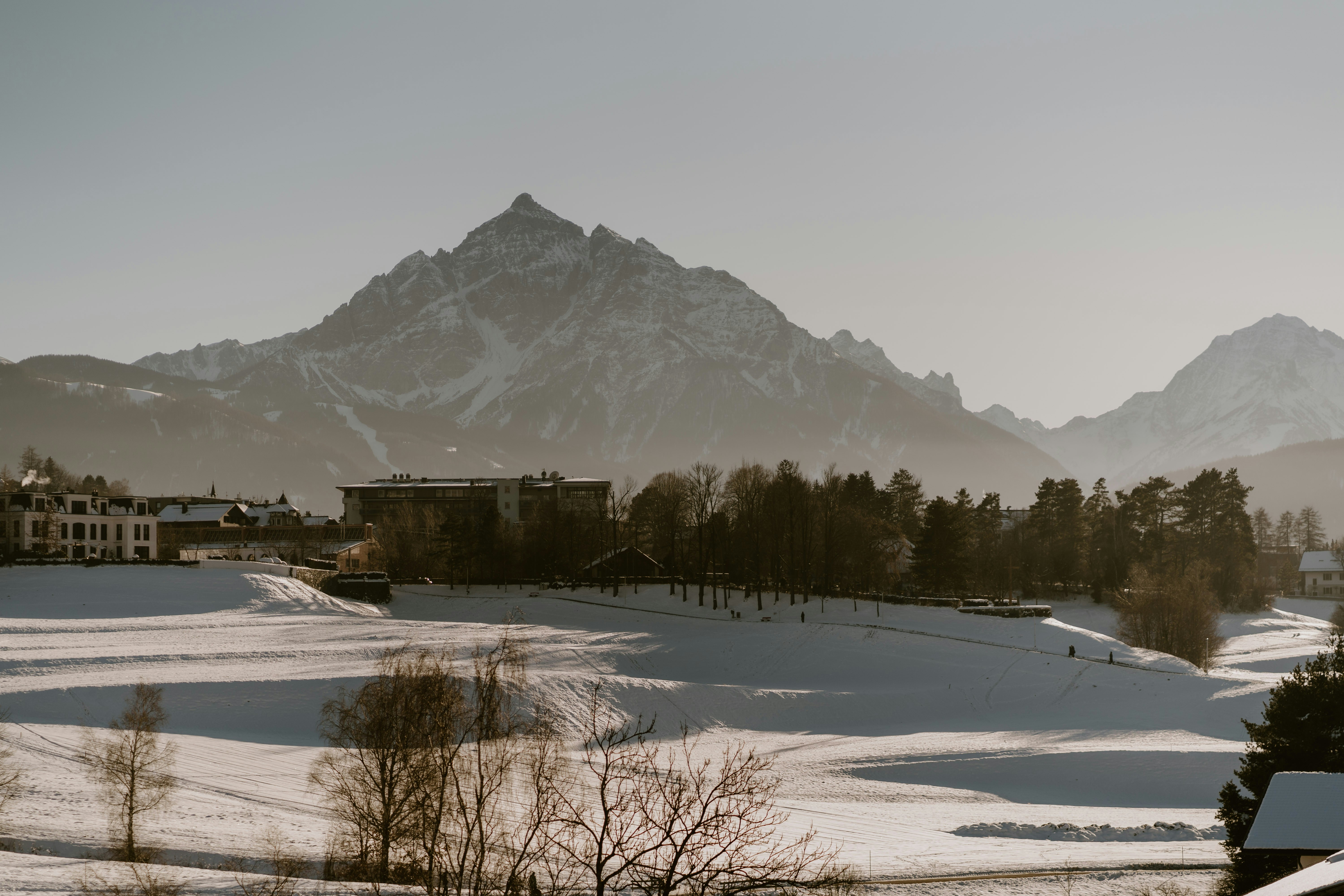 A snow covered field with mountains in the background