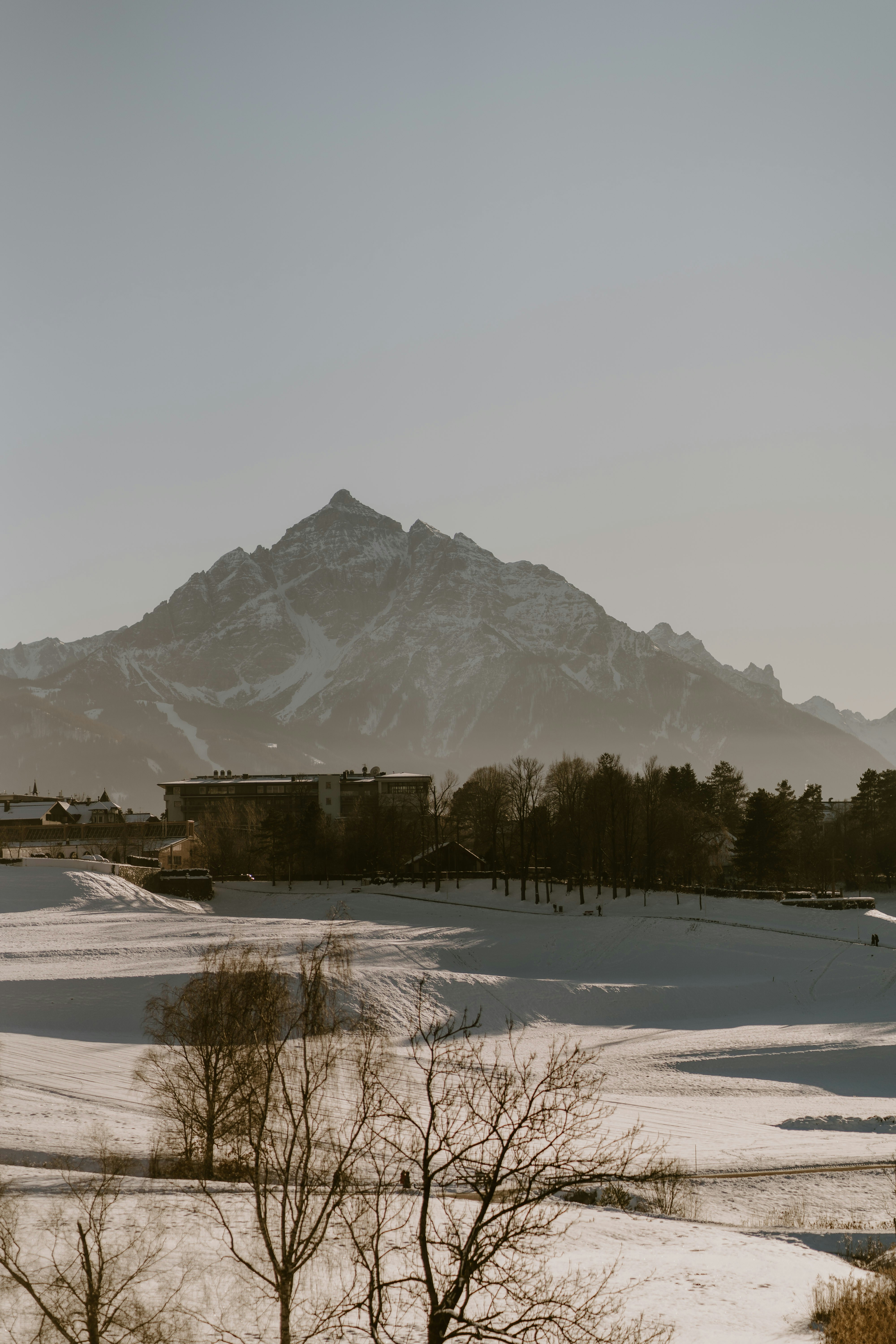 A snow covered field with a mountain in the background