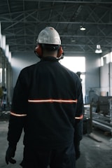 A man in a factory wearing a hard hat