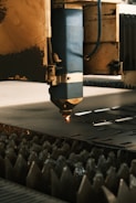 A machine cutting a piece of metal in a factory