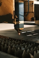 A machine cutting a piece of metal in a factory