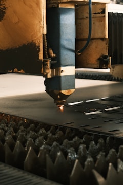 A machine cutting a piece of metal in a factory