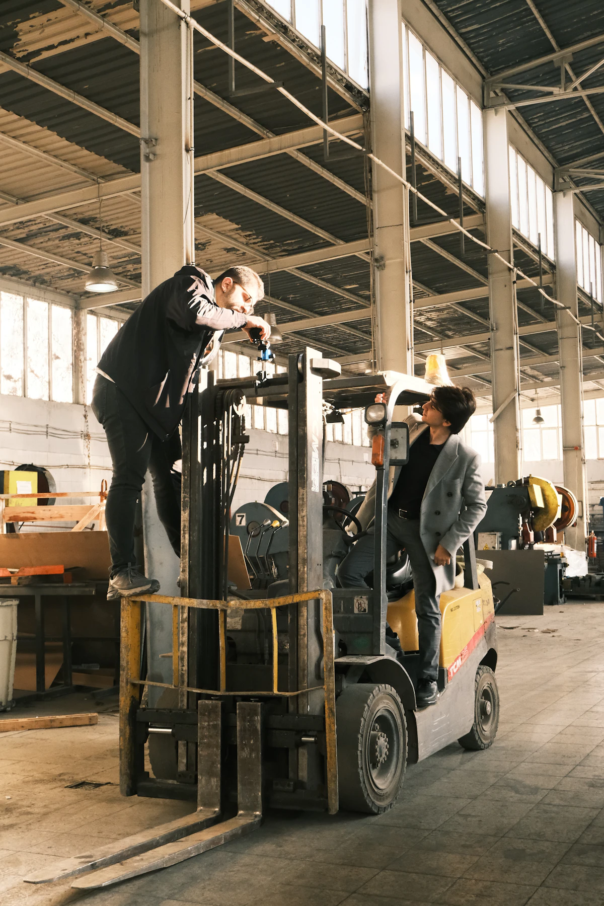 Pekerja di atas forklift di gudang.