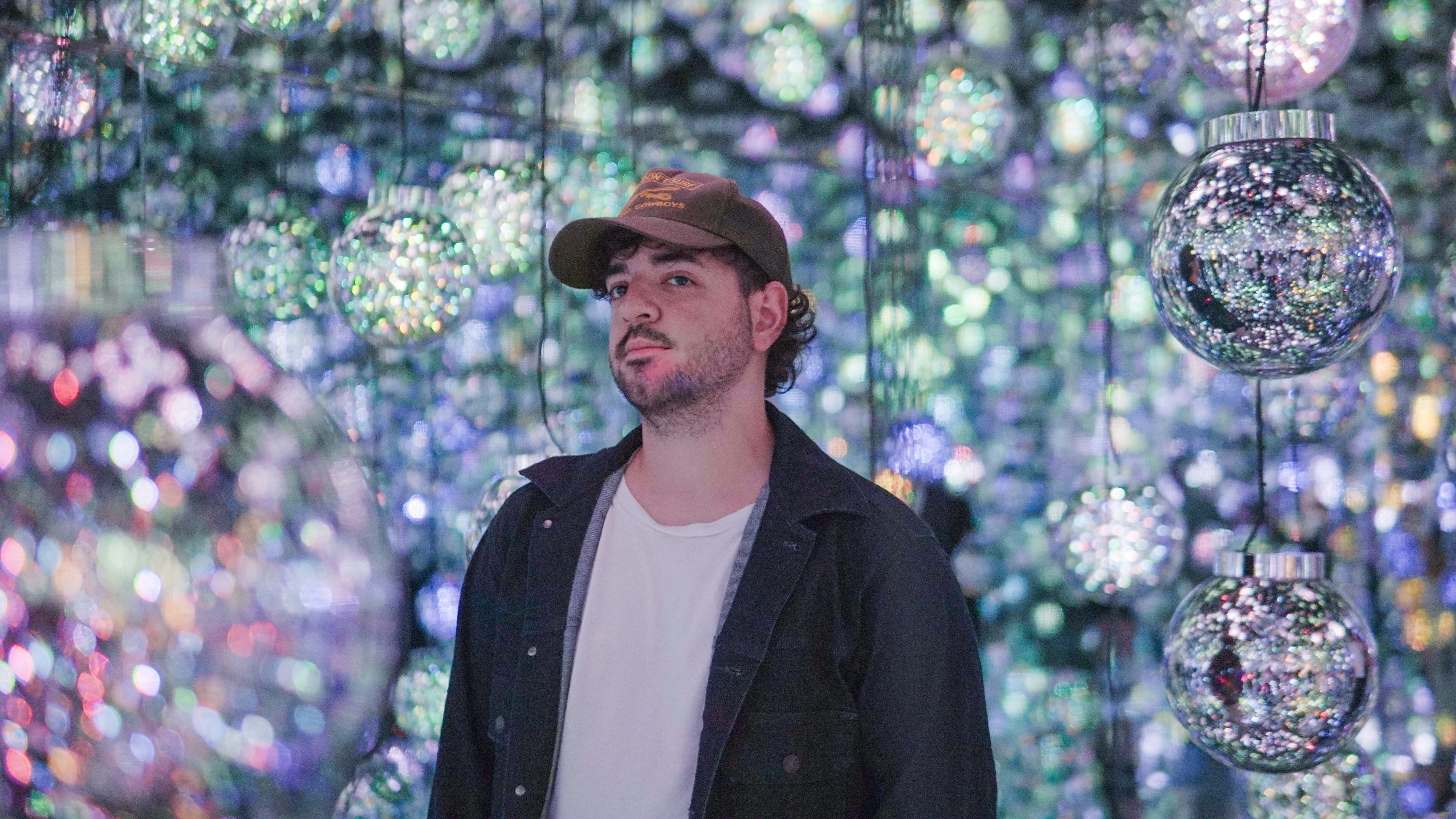 A man standing in front of a wall of balls