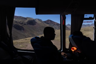A man sitting inside of a bus looking out the window