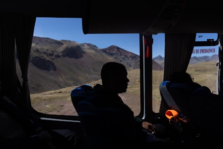 A man sitting inside of a bus looking out the window