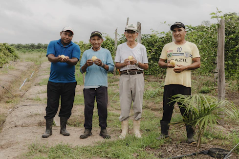 A group of men standing next to each other on a dirt road
