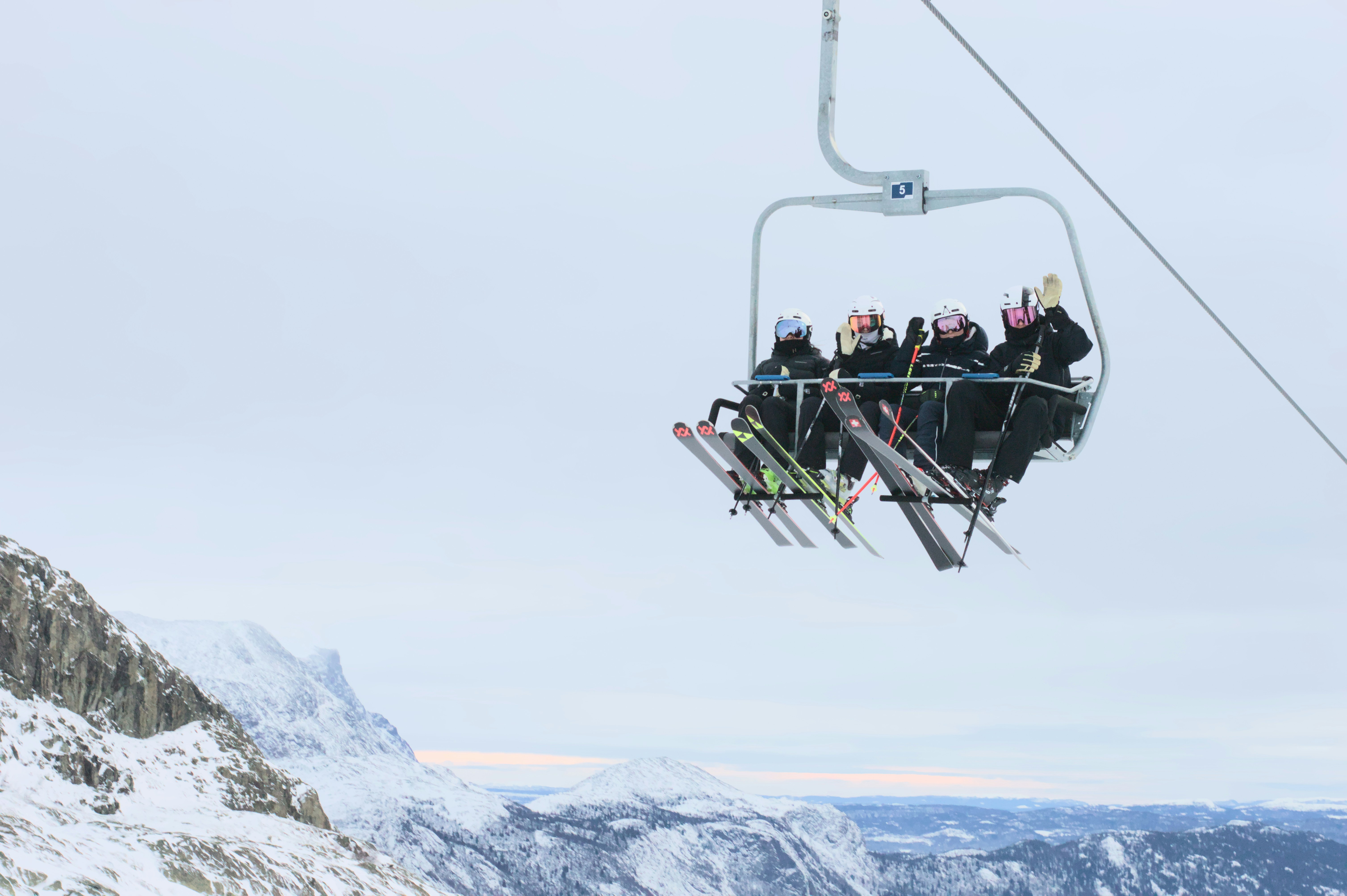 A group of people riding a ski lift up the side of a mountain photo ...