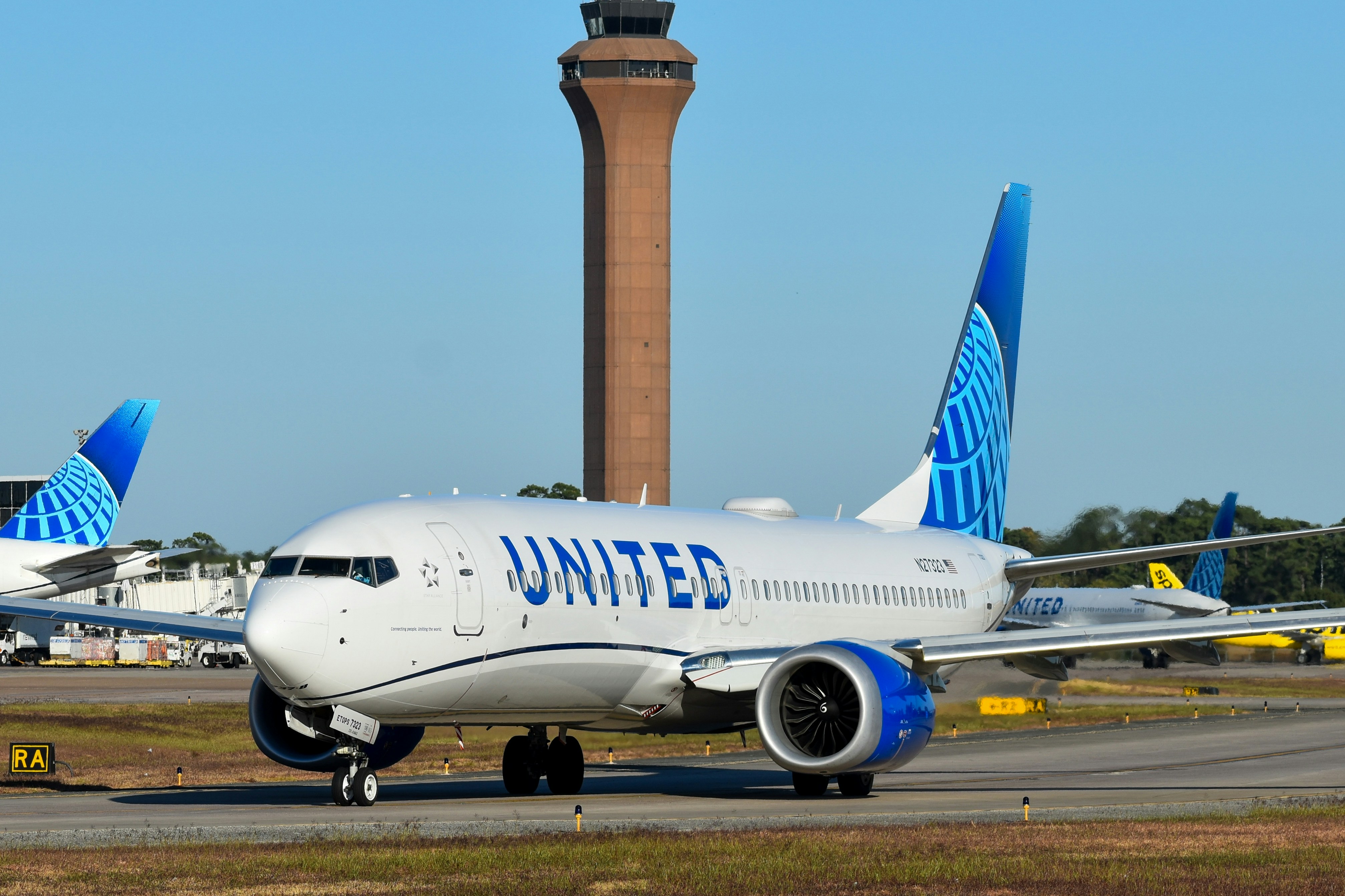 A large jetliner sitting on top of an airport runway, United Airlines 737 MAX in Houston (IAH)