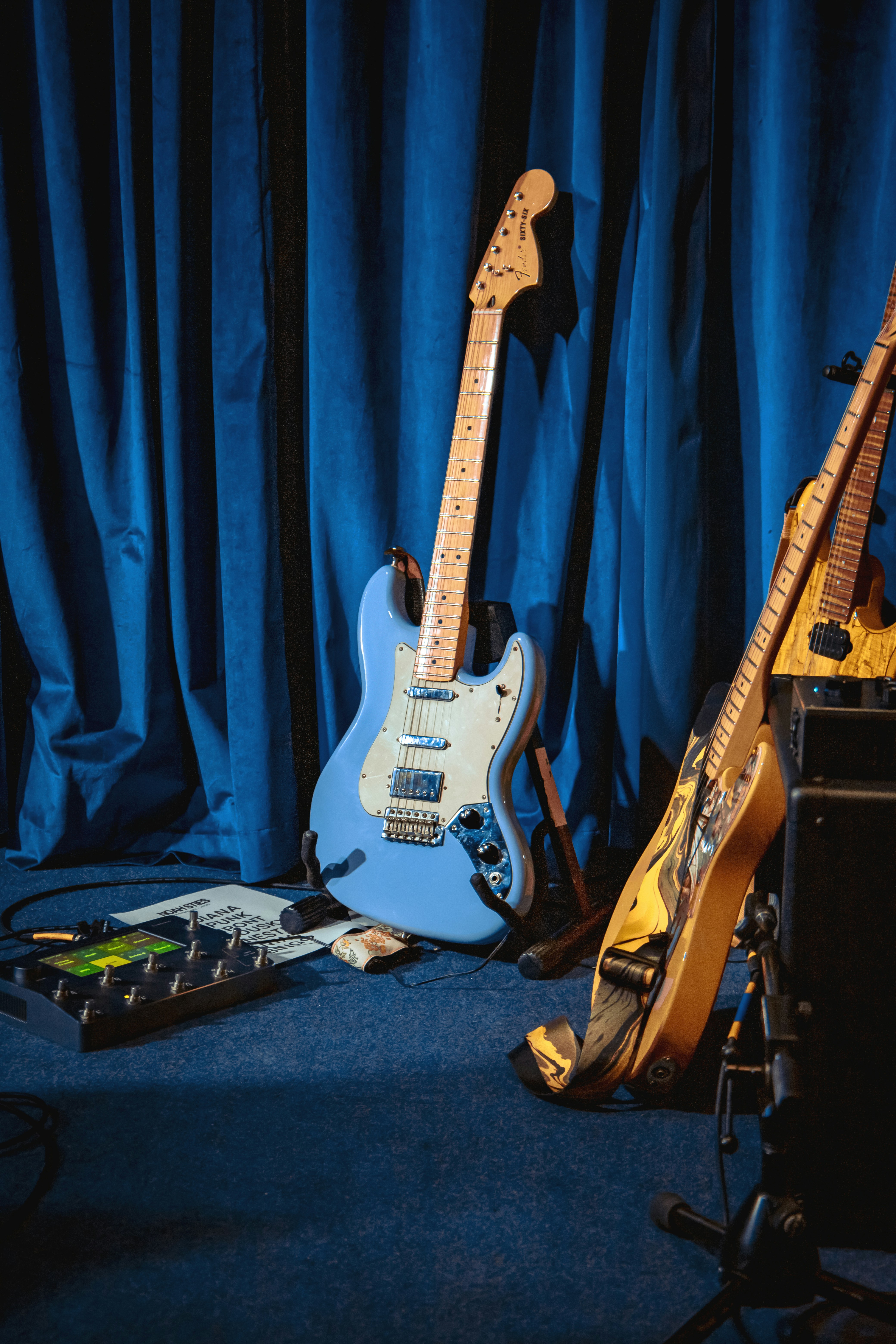 Eine blaue Gitarre und anderes musikalisches Equipment auf einer Bühne