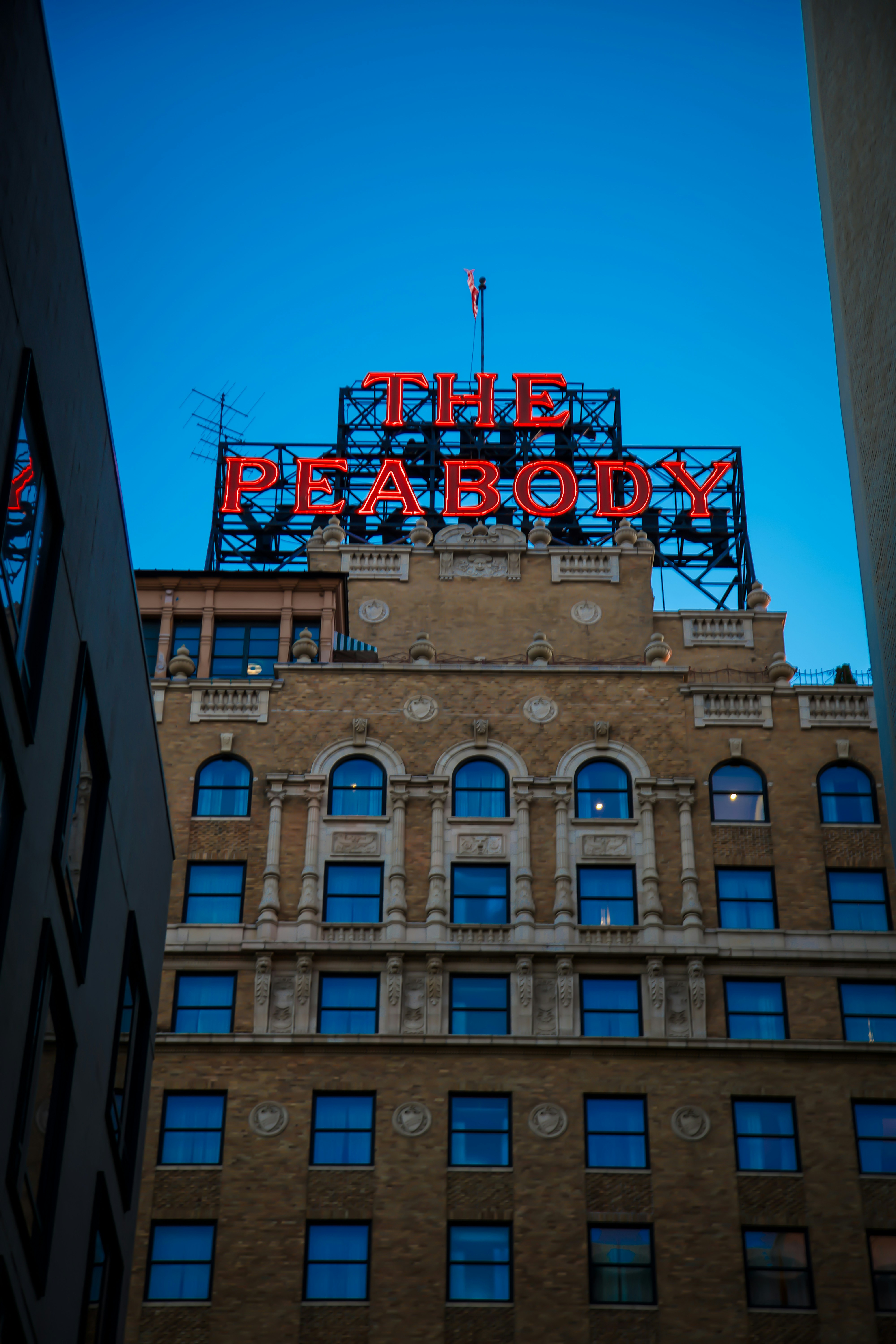A tall building with a neon sign on top of it