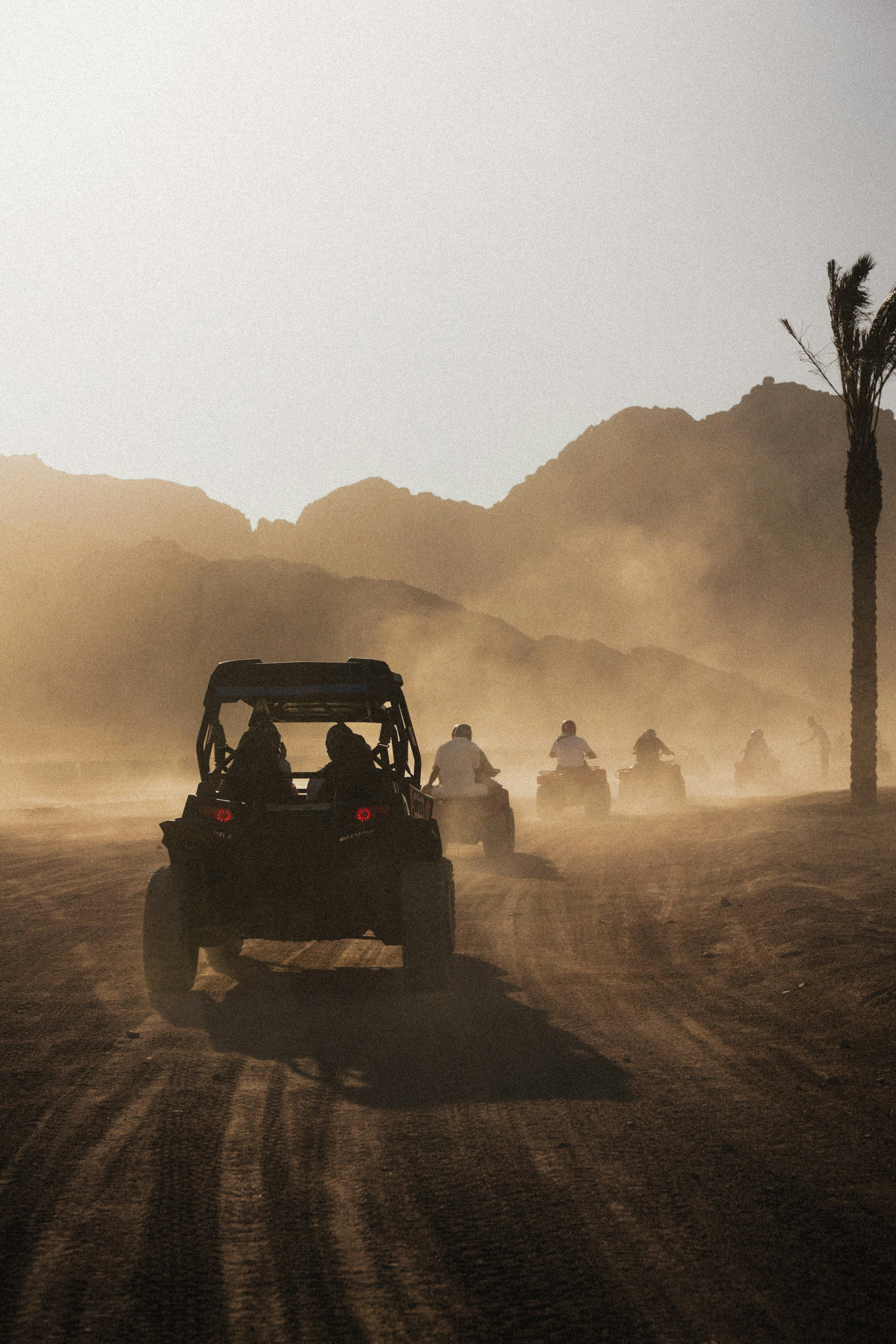 A group of people riding in a buggy on a dirt road