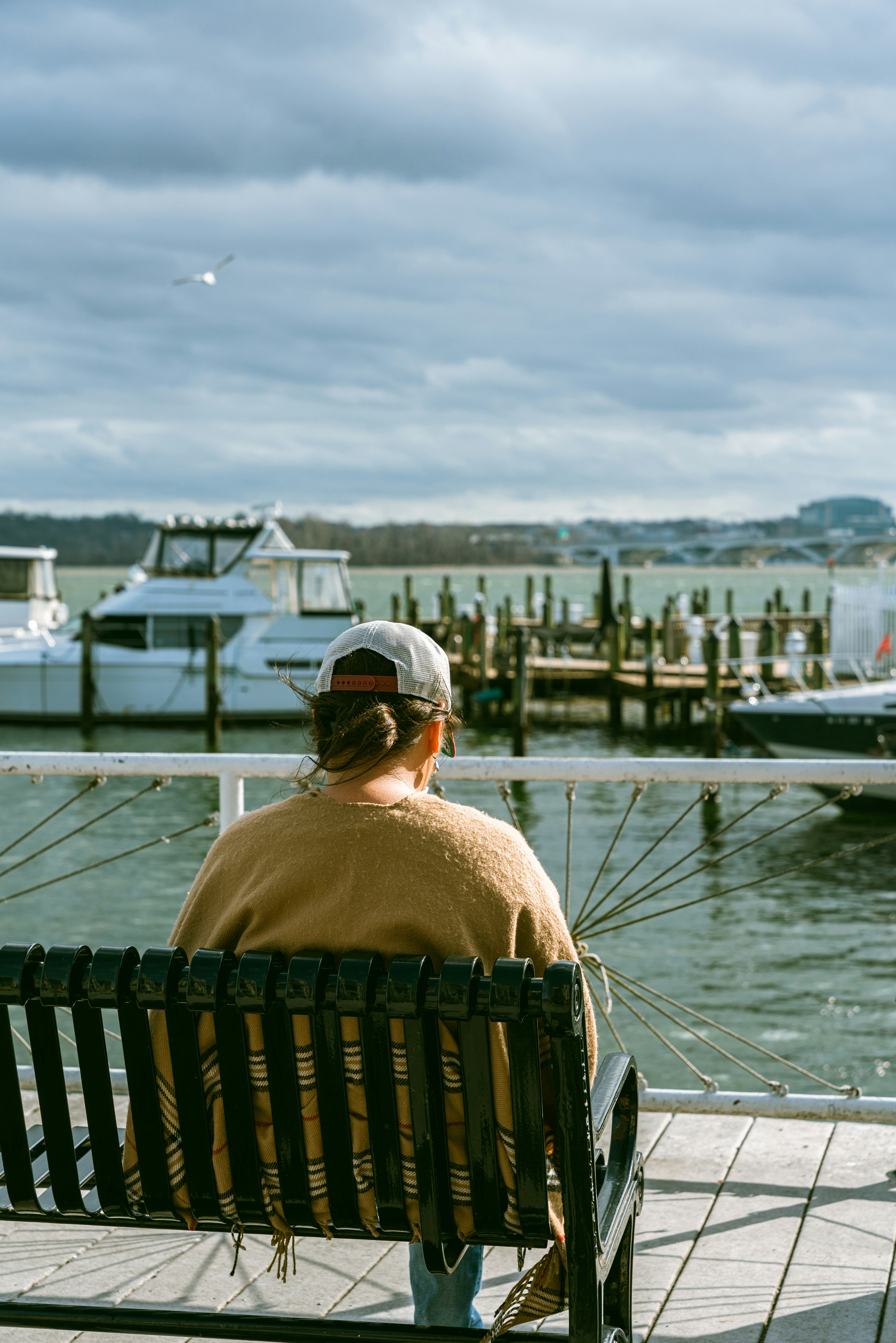 A man sitting on a bench looking out at the water