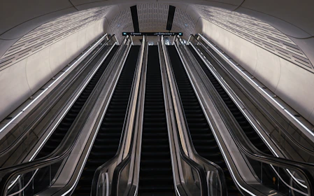 An escalator in a subway station with two escalators