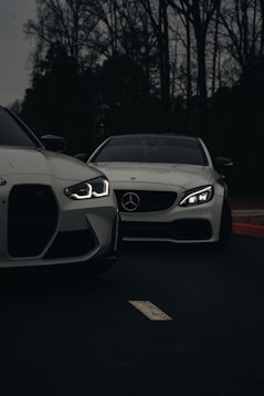 A couple of white cars parked next to each other
