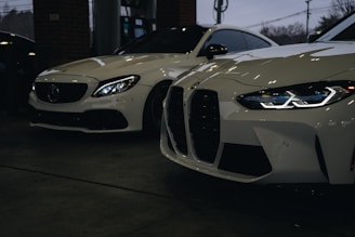 A couple of white cars parked next to each other