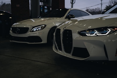 A couple of white cars parked next to each other